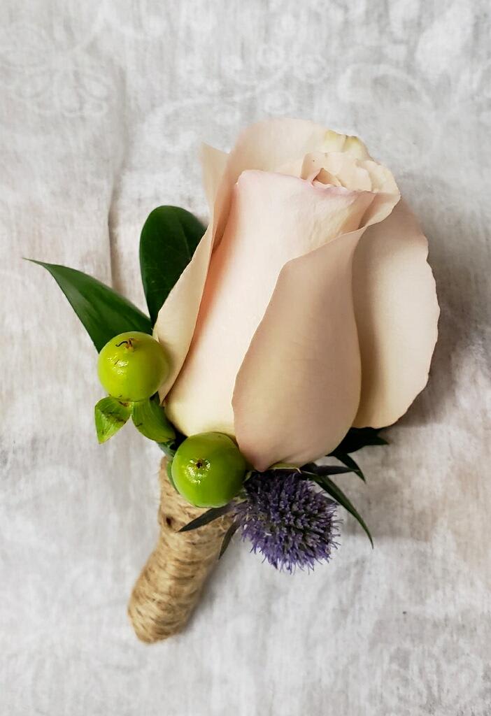 Single pale pink rose boutonniere with green berries and purple accent flower