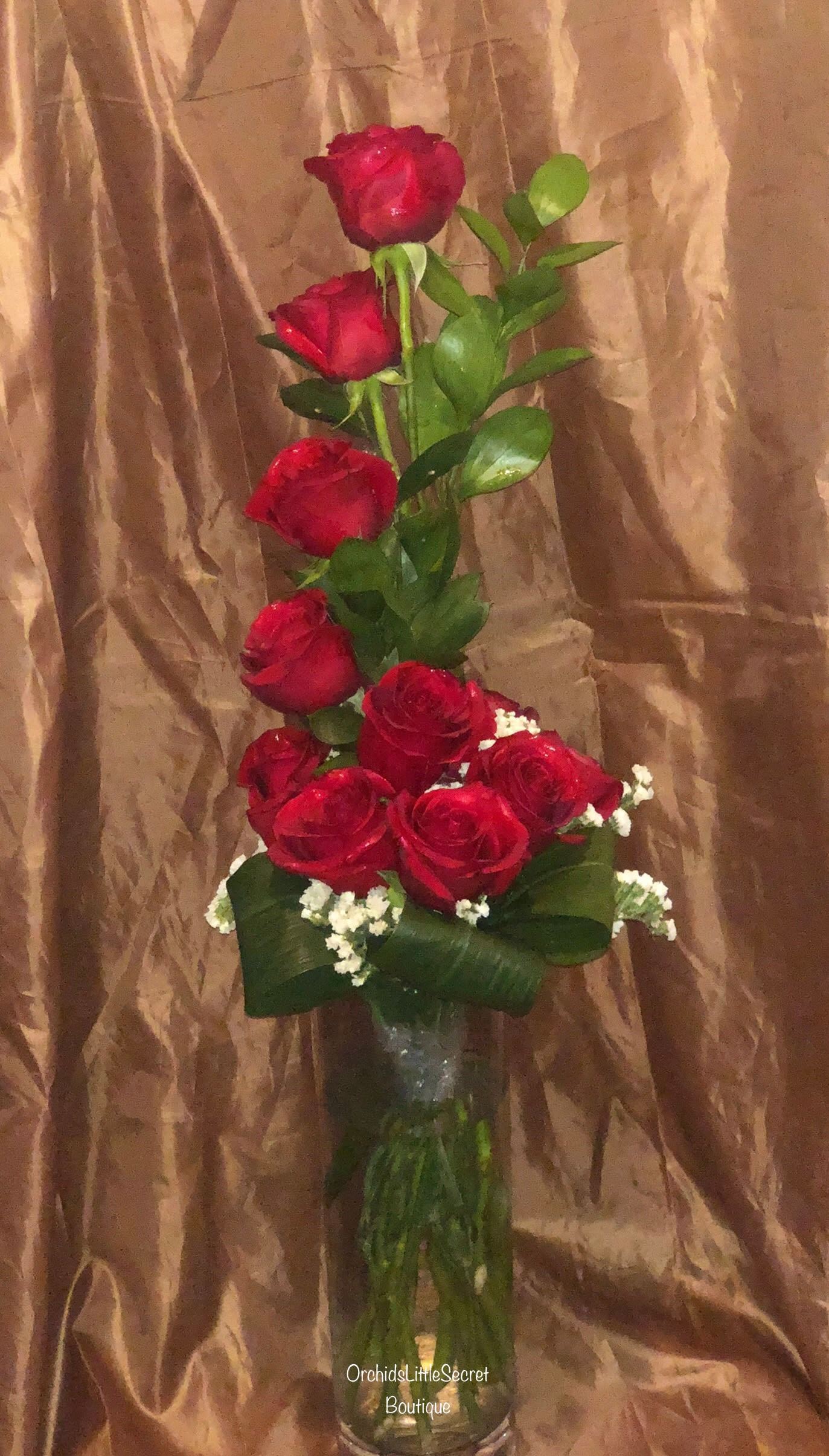 Tall bouquet of red roses in a clear glass vase