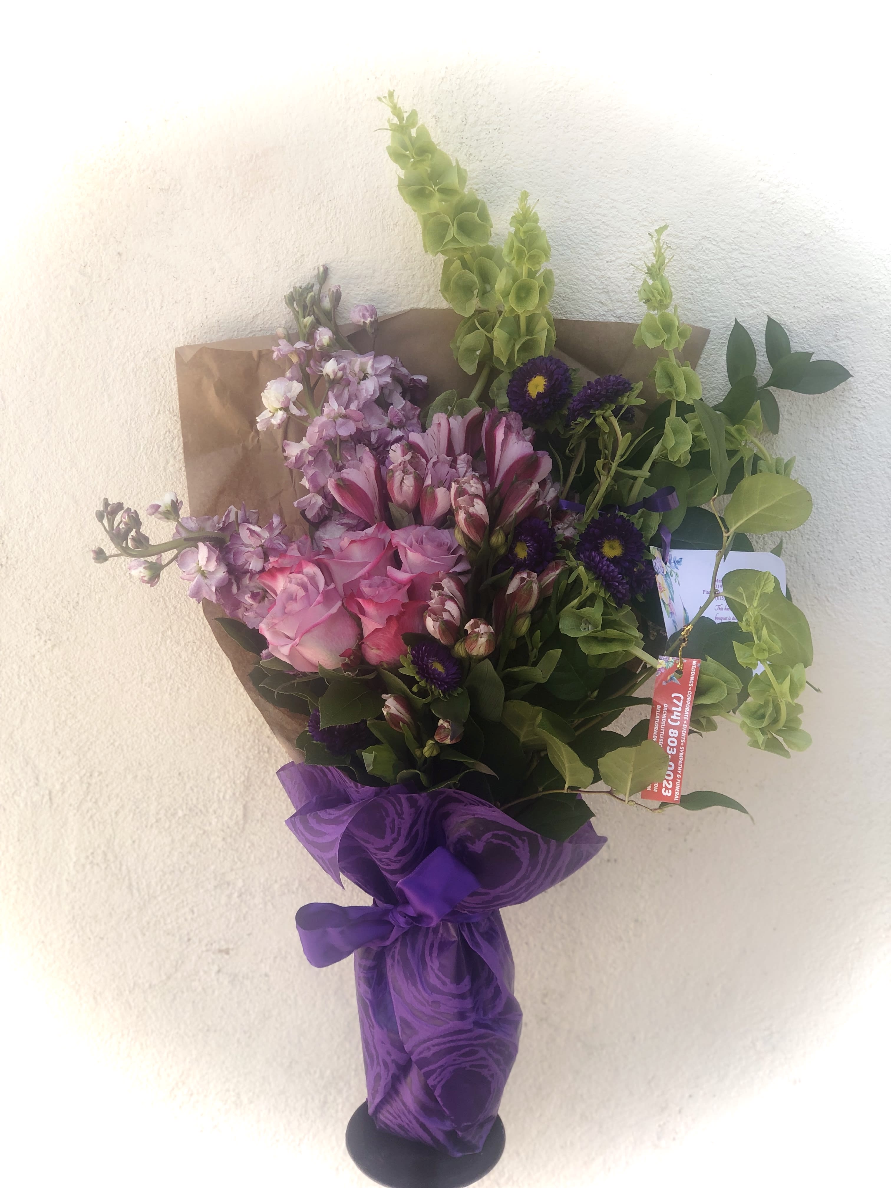 Bouquet of pink and purple flowers wrapped in purple paper