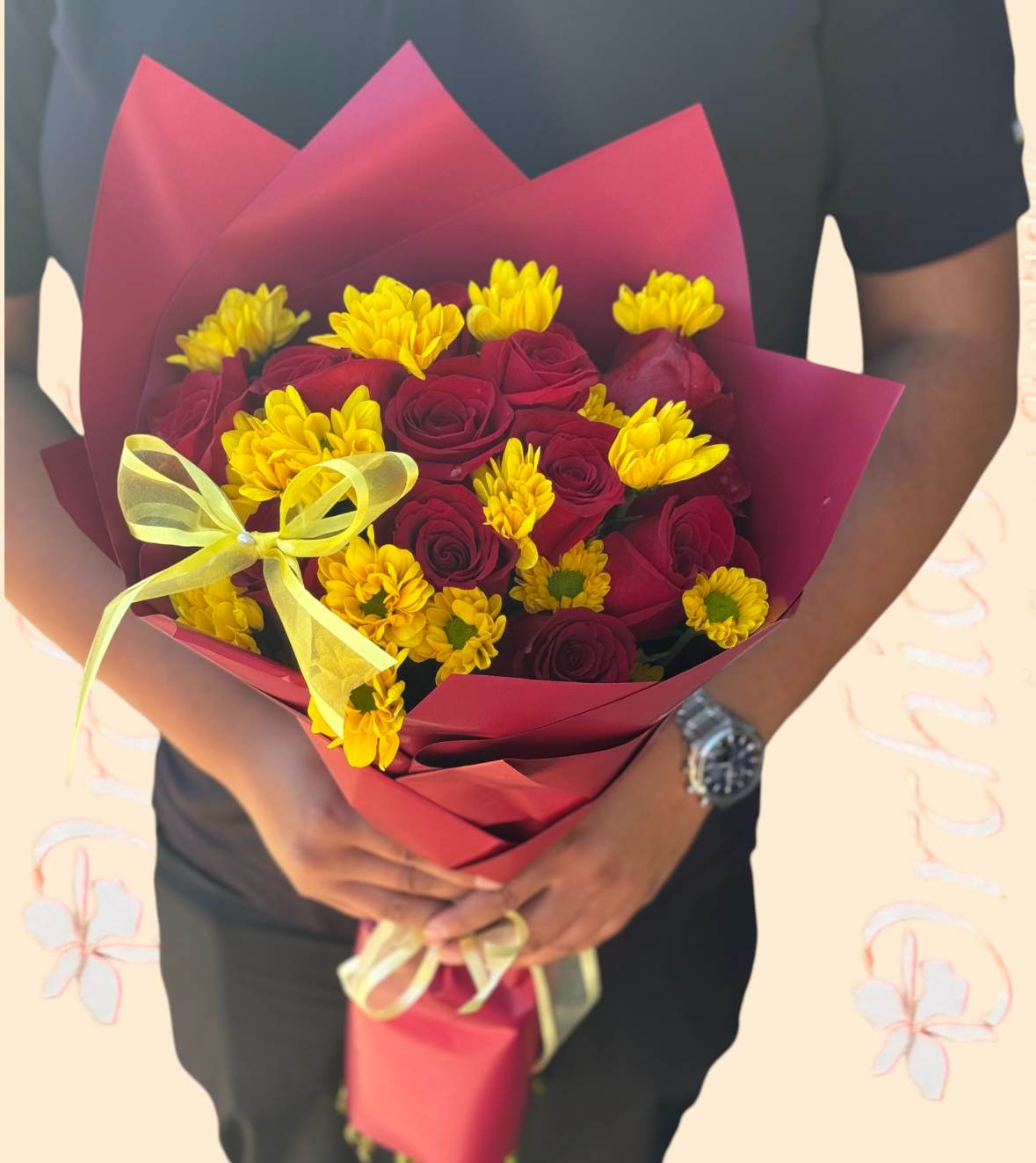 Bouquet of red roses and yellow daisies wrapped in burgundy paper