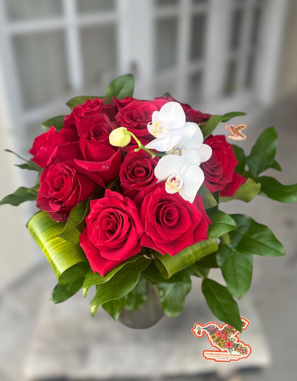 Red roses with white orchids in a glass vase
