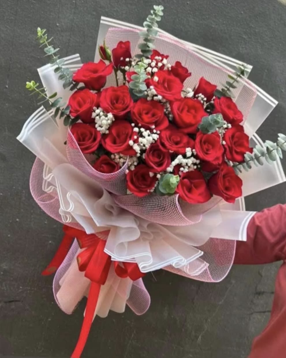 Crimson Passion Bouquet - "The timeless statement of deep love and devotion. This breathtaking bouquet features premium red roses accented with delicate baby's breath and fresh eucalyptus. Elegantly hand-wrapped in layered Korean-style paper and finished with a striking red bow, it’s crafted to make an unforgettable impression."