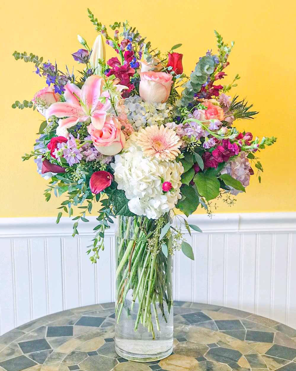Mixed bouquet in a clear glass vase with pink, white, and purple flowers