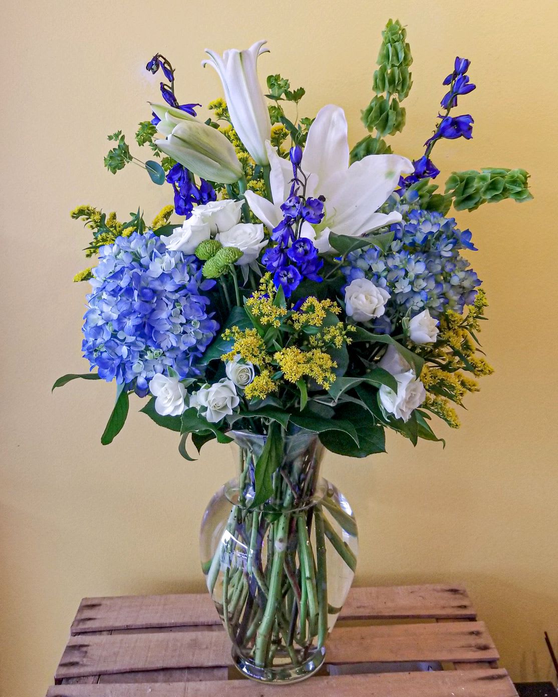 Blue and white flower arrangement in a clear glass vase