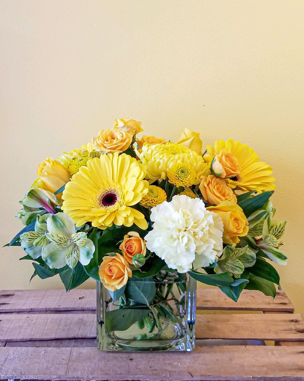 Yellow and white mixed bouquet in a square glass vase
