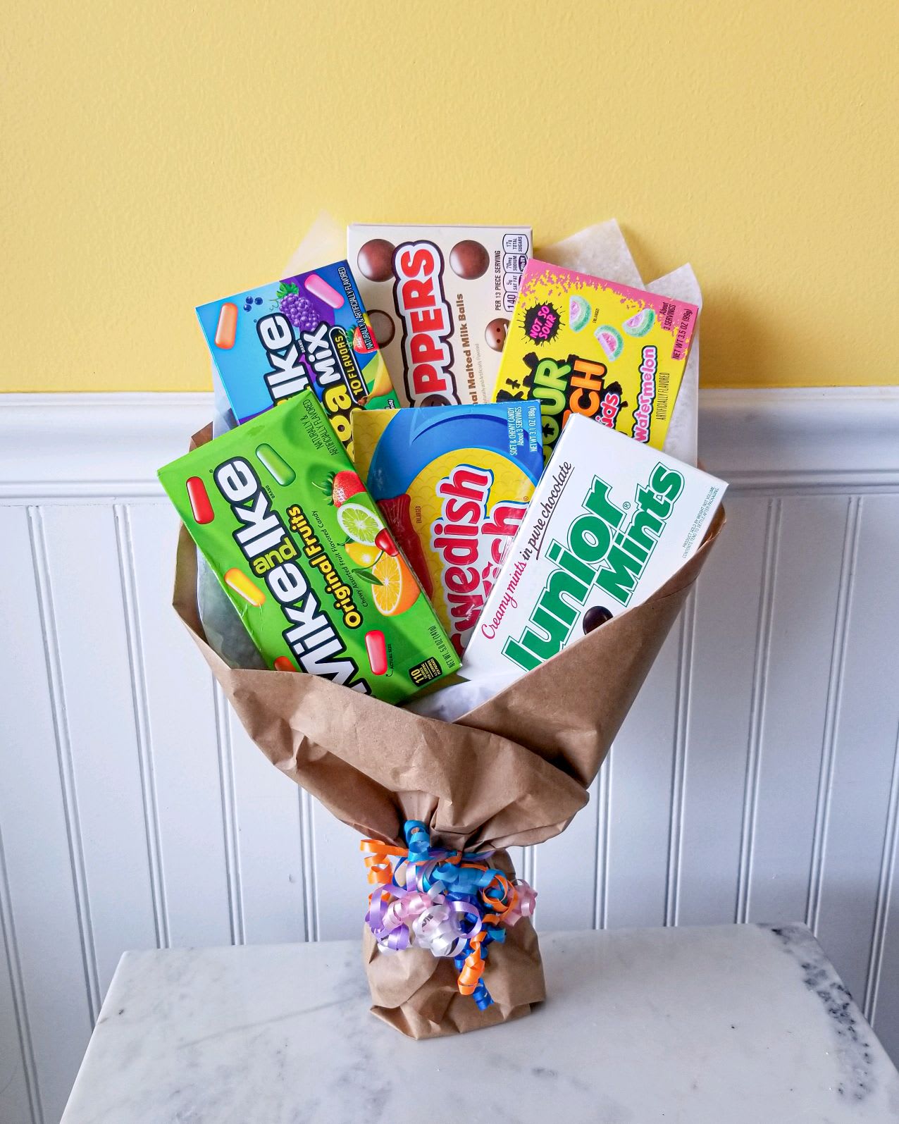 Bouquet of assorted candy boxes wrapped in brown paper