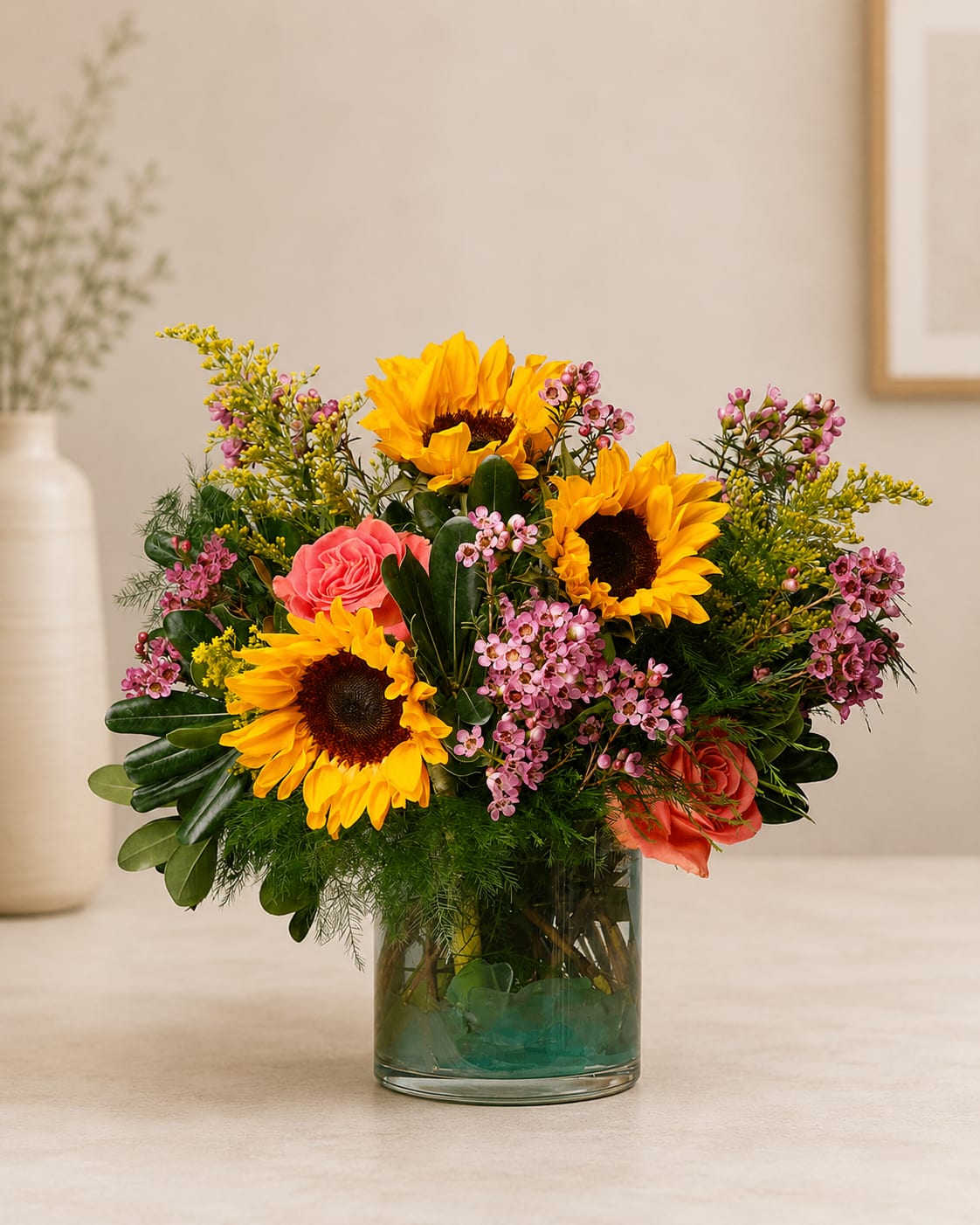 Sunflower and rose arrangement in a clear glass vase