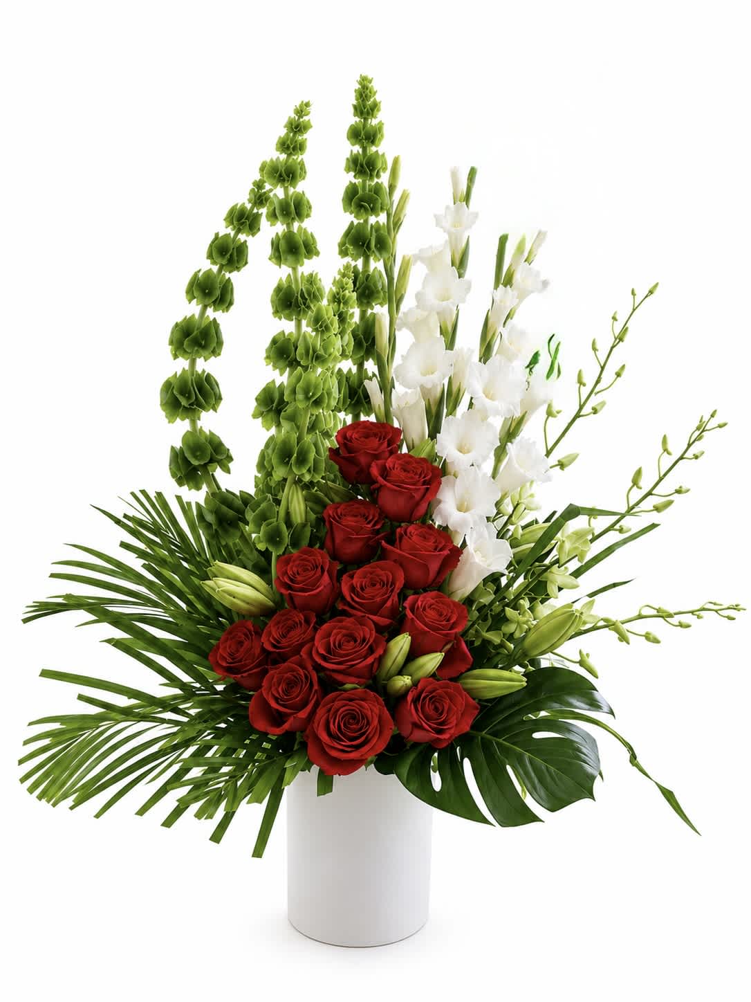Red roses and white orchids in a white vase with tall green accents