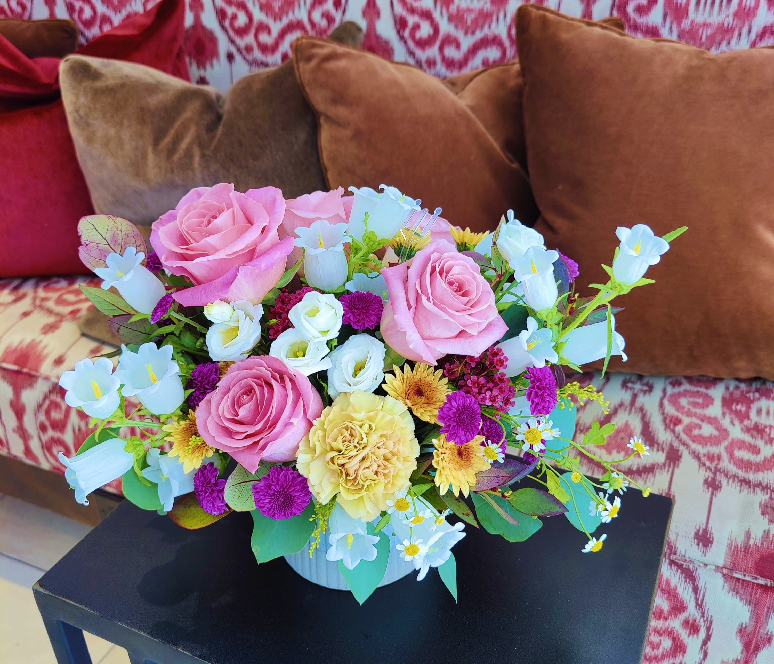 Pink roses and mixed pastel flowers arranged in a white vase