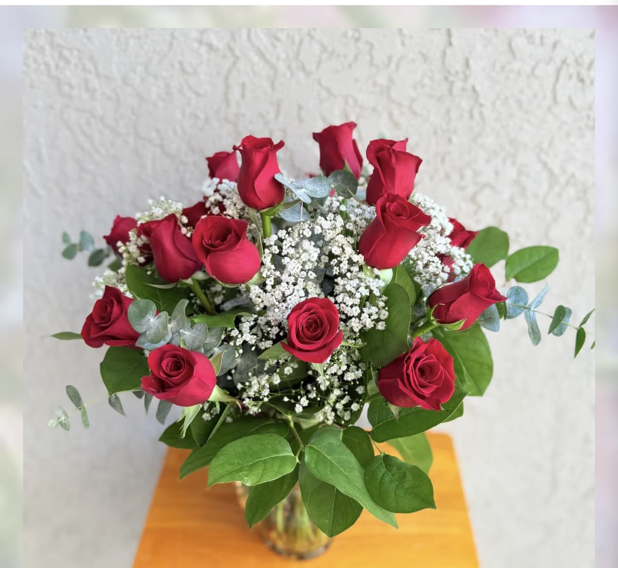 Bouquet of red roses with white baby's breath in a glass vase