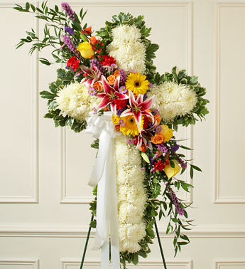 Peace and Prayers Cross (Easel Stand) - Solid White Standing Cross with Bright Flower Break This beautiful floral tribute shows your compassion, faith and love during this difficult time. This standing spray arrangement â in the shape of a cross â is created from fresh white mums and bright-colored roses, lilies, Gerbera daisies, carnations and more Traditionally sent directly to the funeral home by family members or friends and displayed on a stand Our florists use only the freshest flowers available so varieties and colors may vary Measures approximately 42"H x 28"L without easel