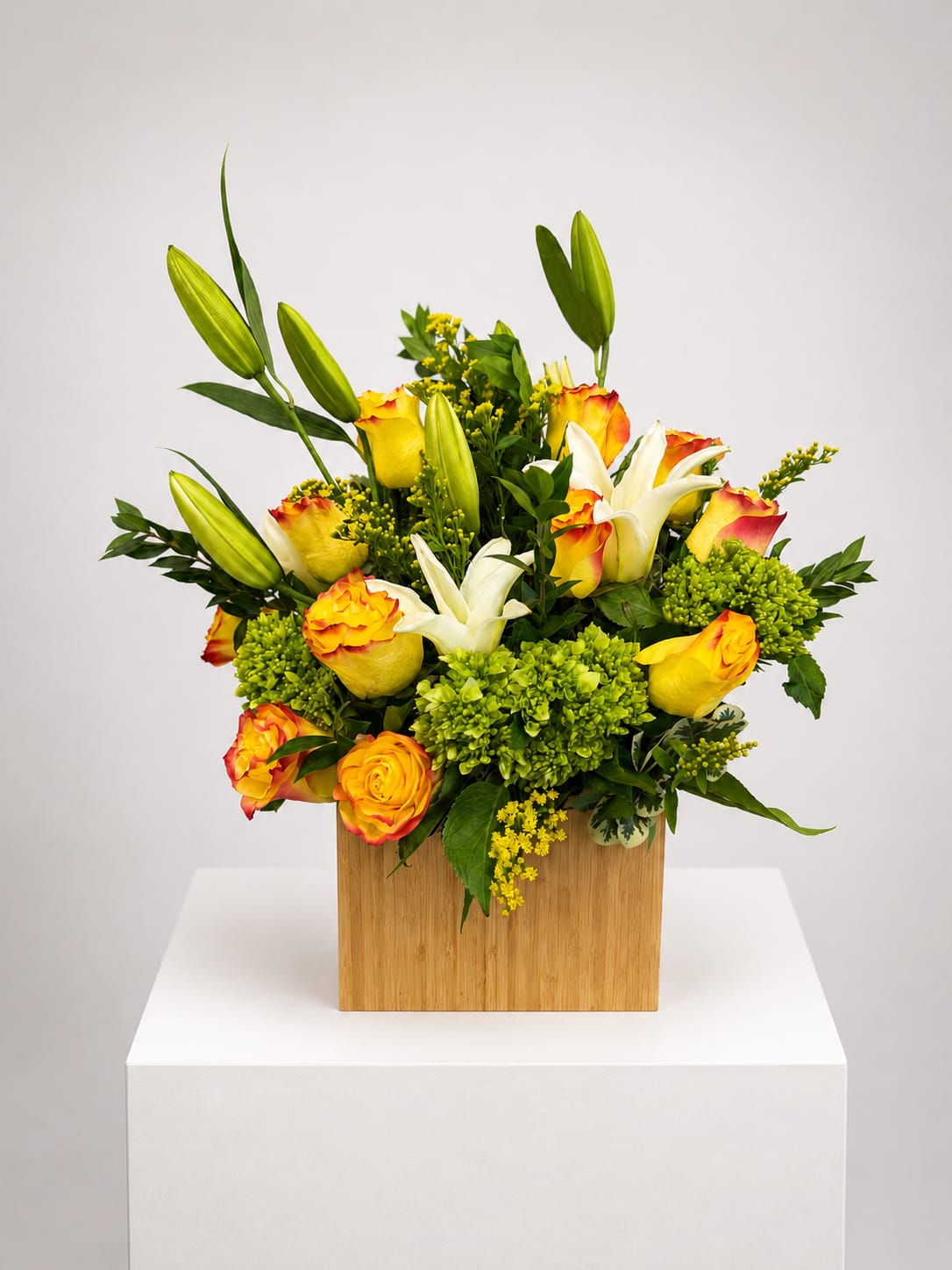 Yellow and white roses with lilies in a wooden box