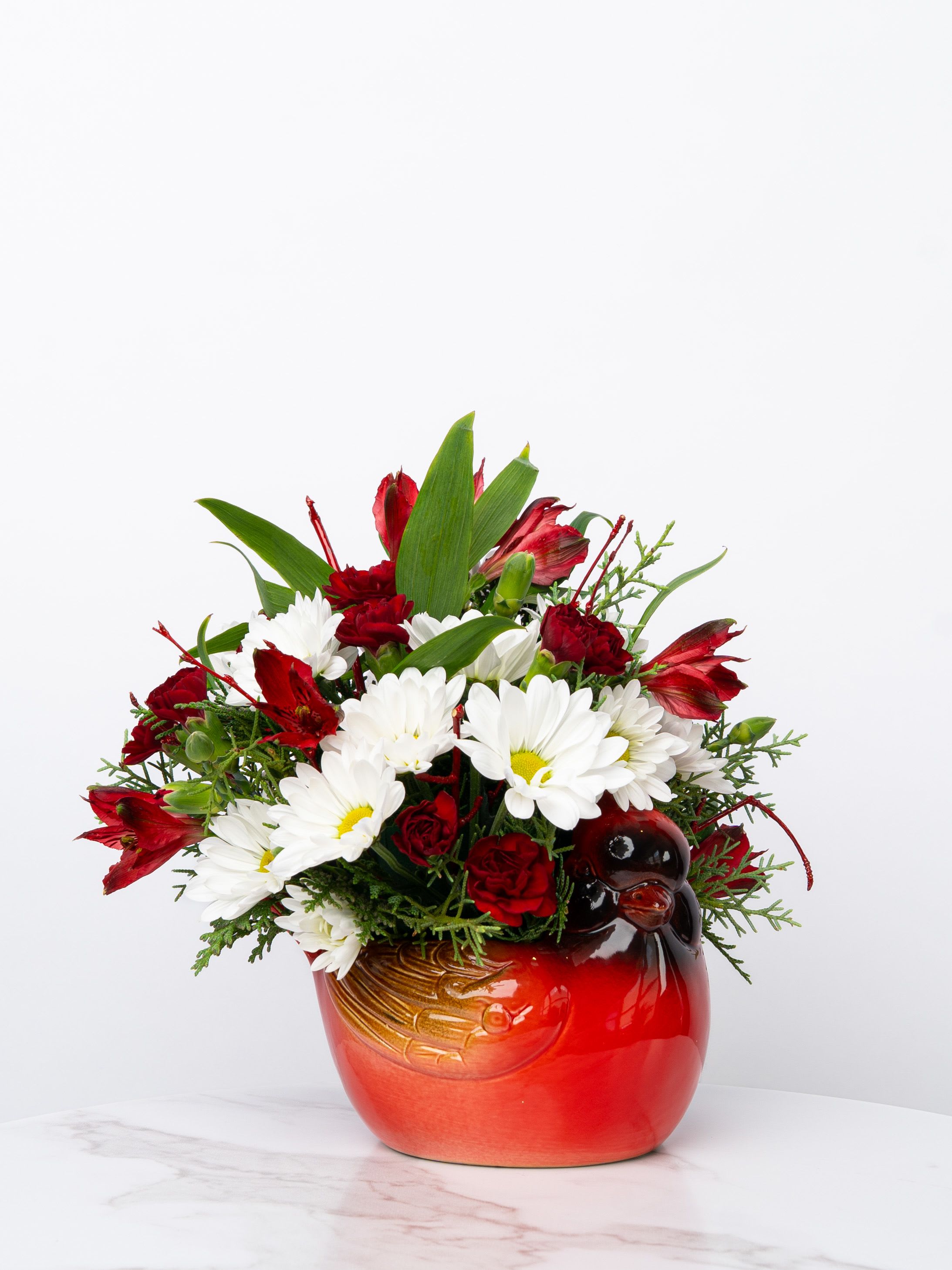Our Honor Collection: Cheerful Cardinal - Our Honor Collection's Cheerful Cardinal arrangement is designed with rich, patriotic hues in a charming ceramic cardinal vase right here in Valparaiso to express hope, warmth, and heartfelt sentiment. This arrangement can arrive in white, red/white (as shown), or red/white/blue.  At Schultz Floral, each arrangement is one of a kind and styled just for your order in our Valparaiso Shop. Because we always use the freshest blooms, your final arrangement may not look exactly as pictured due to daily availability.