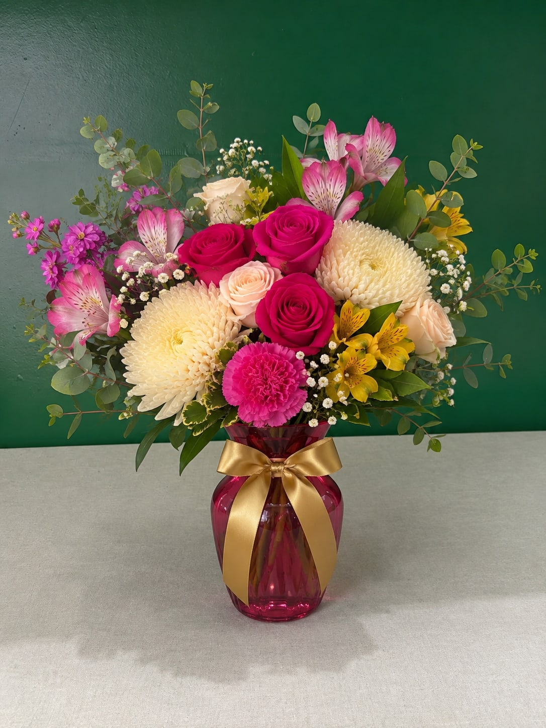 Bouquet of pink roses, chrysanthemums, and alstroemeria in a pink vase
