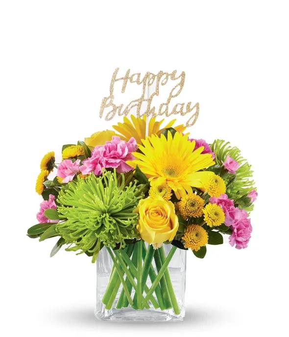 Bright mixed bouquet in a clear vase with a Happy Birthday topper