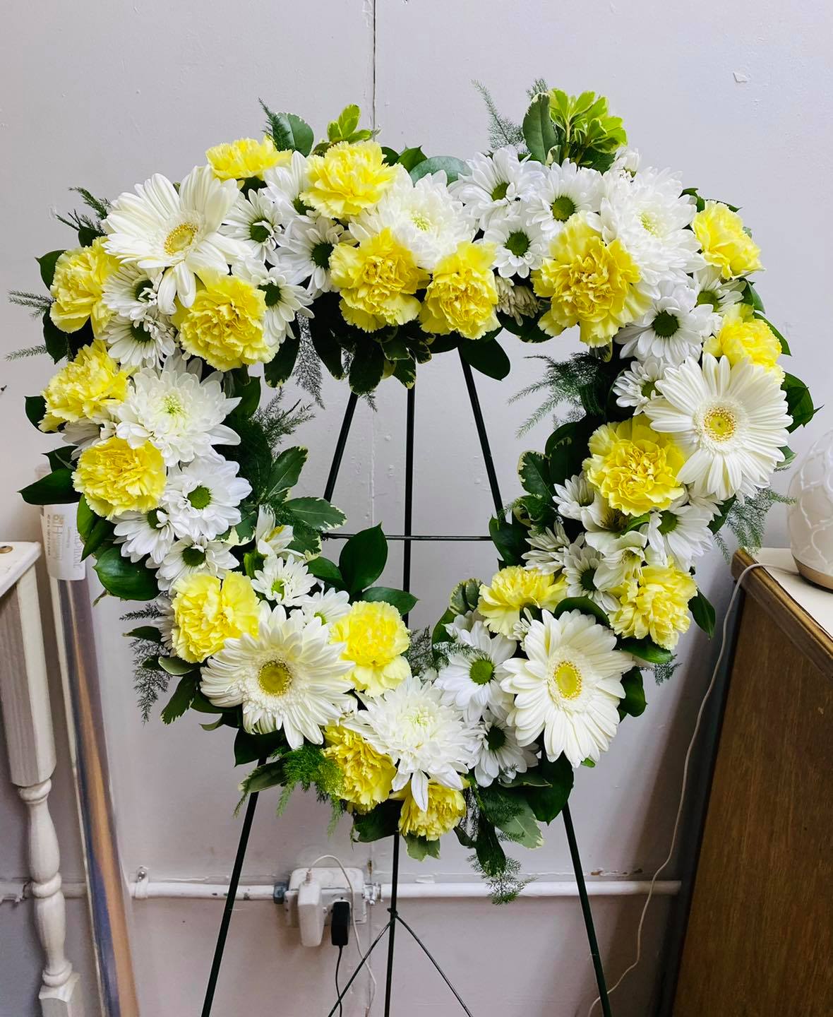 Heart-shaped floral wreath with white daisies and yellow carnations