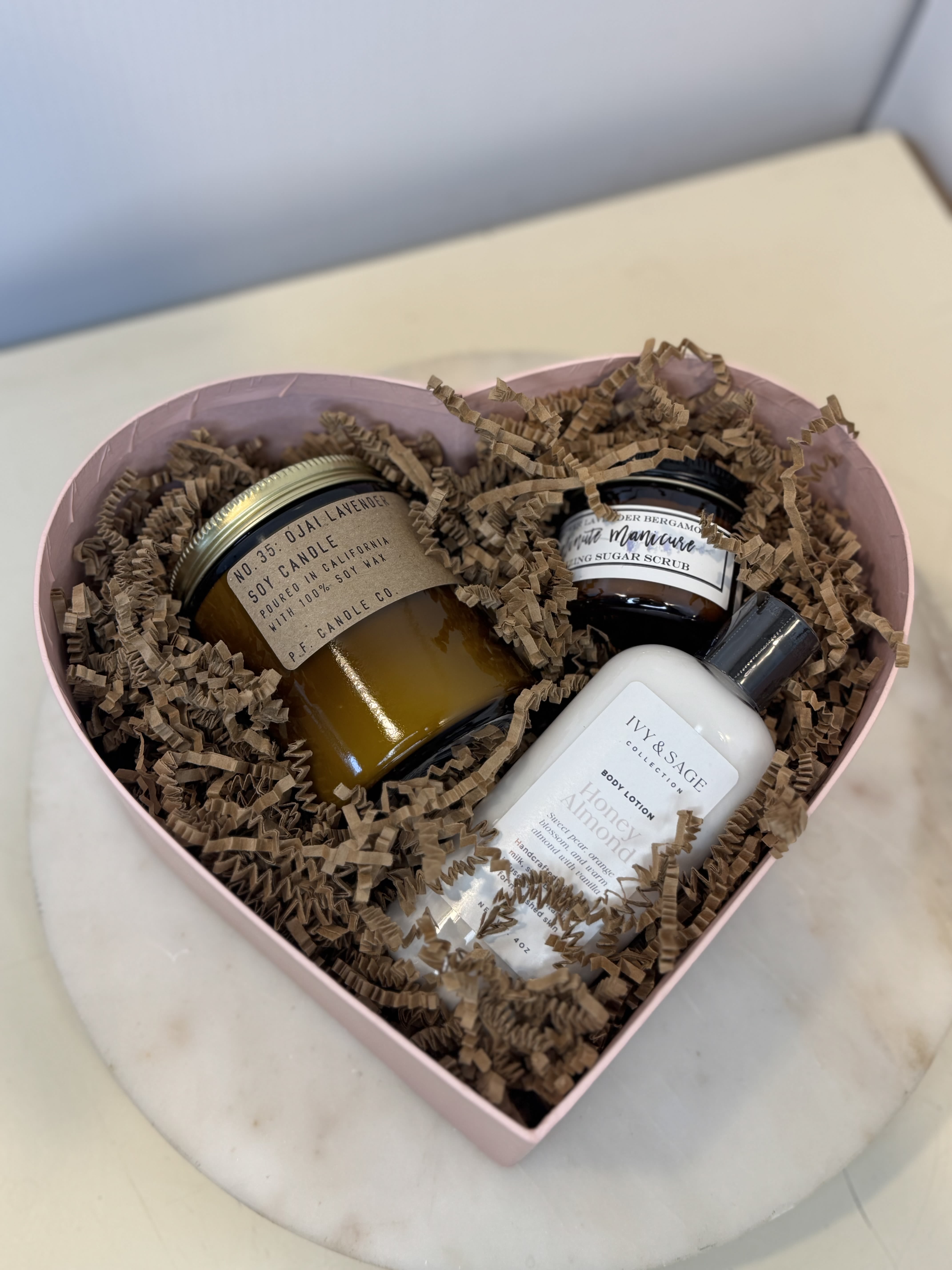 Heart-shaped gift box with candles, body lotion, and sugar scrub
