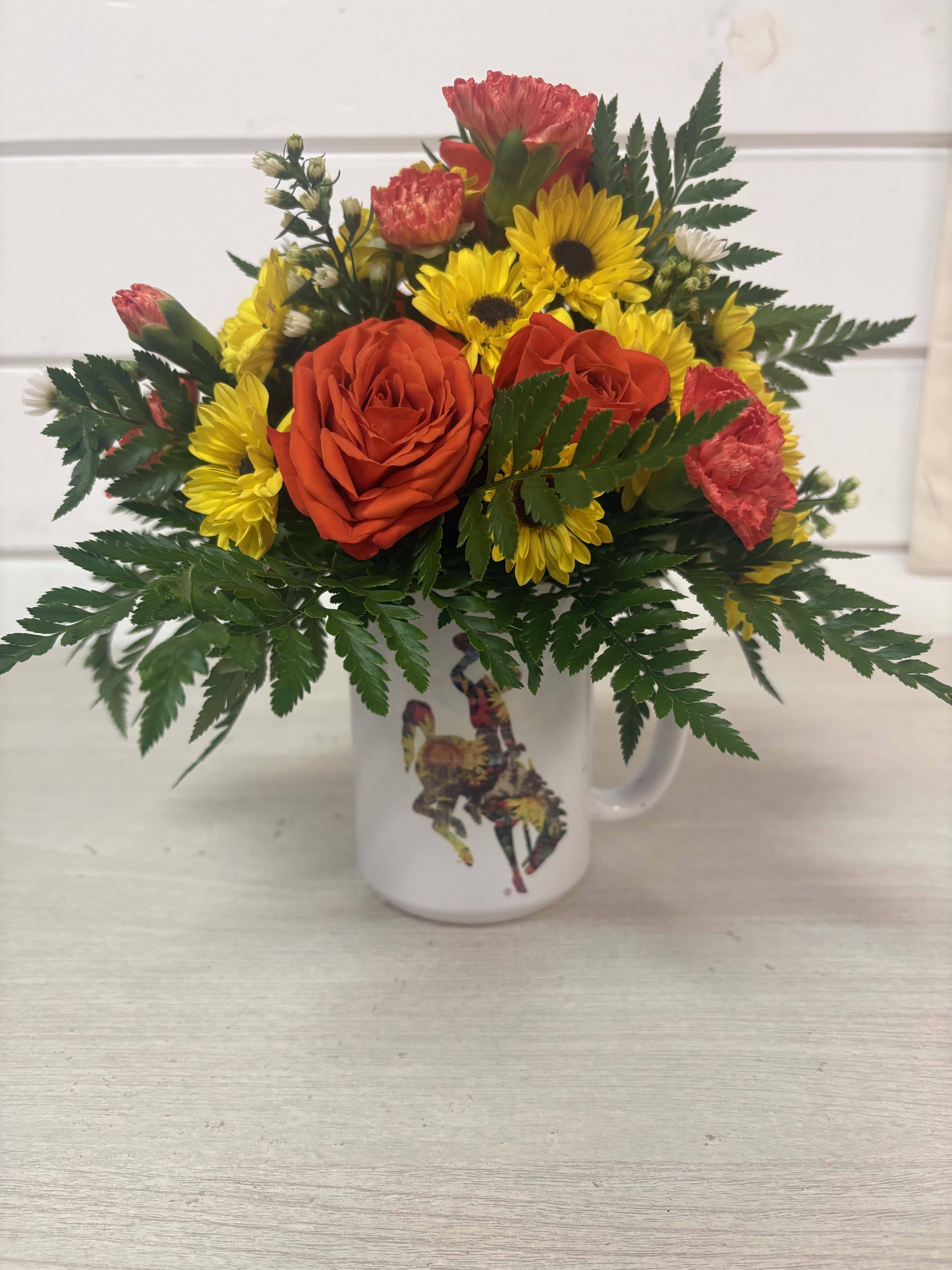 Bouquet of red roses and yellow daisies in a white mug