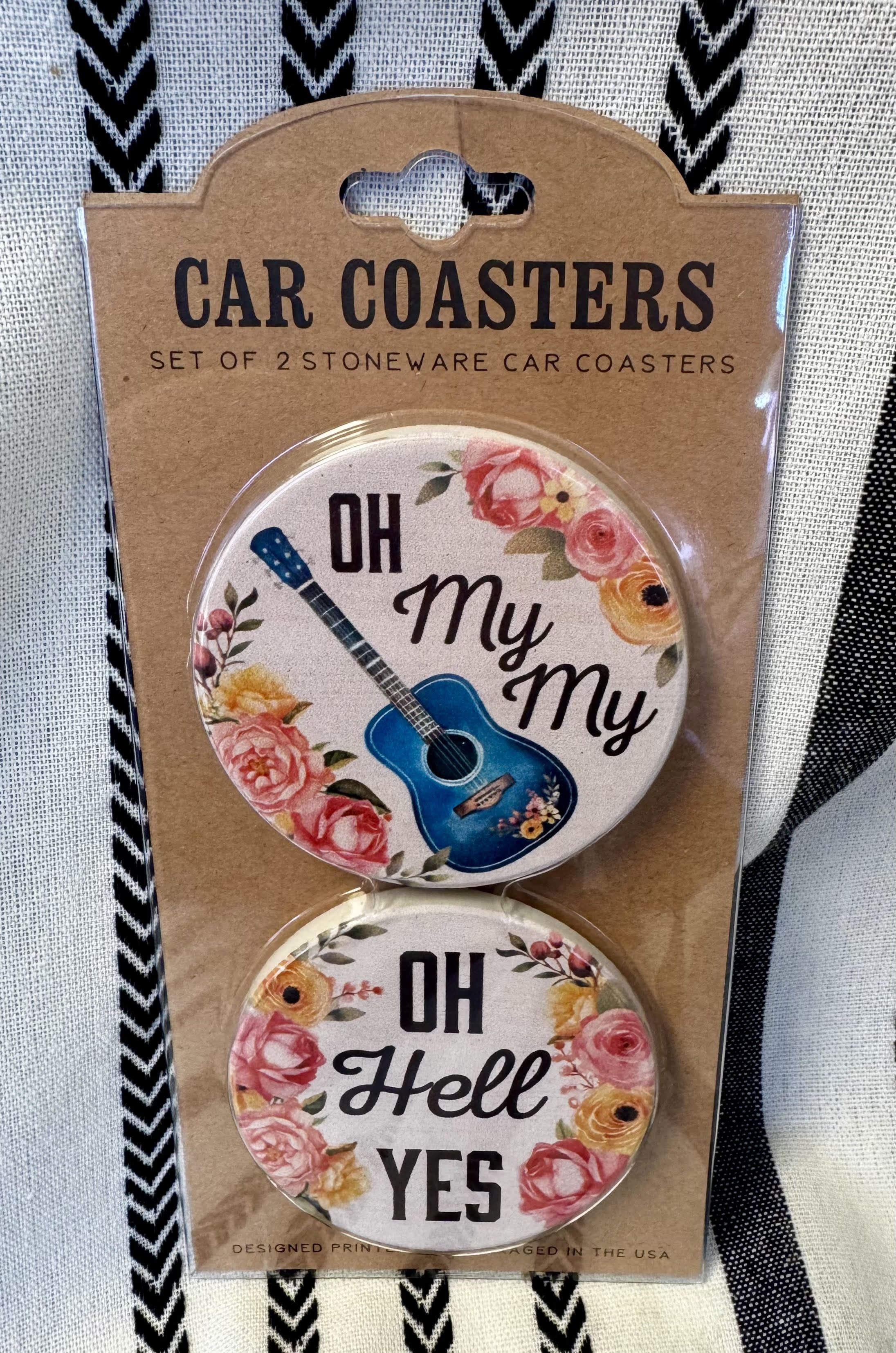 Packaged set of two round car coasters with floral guitar designs