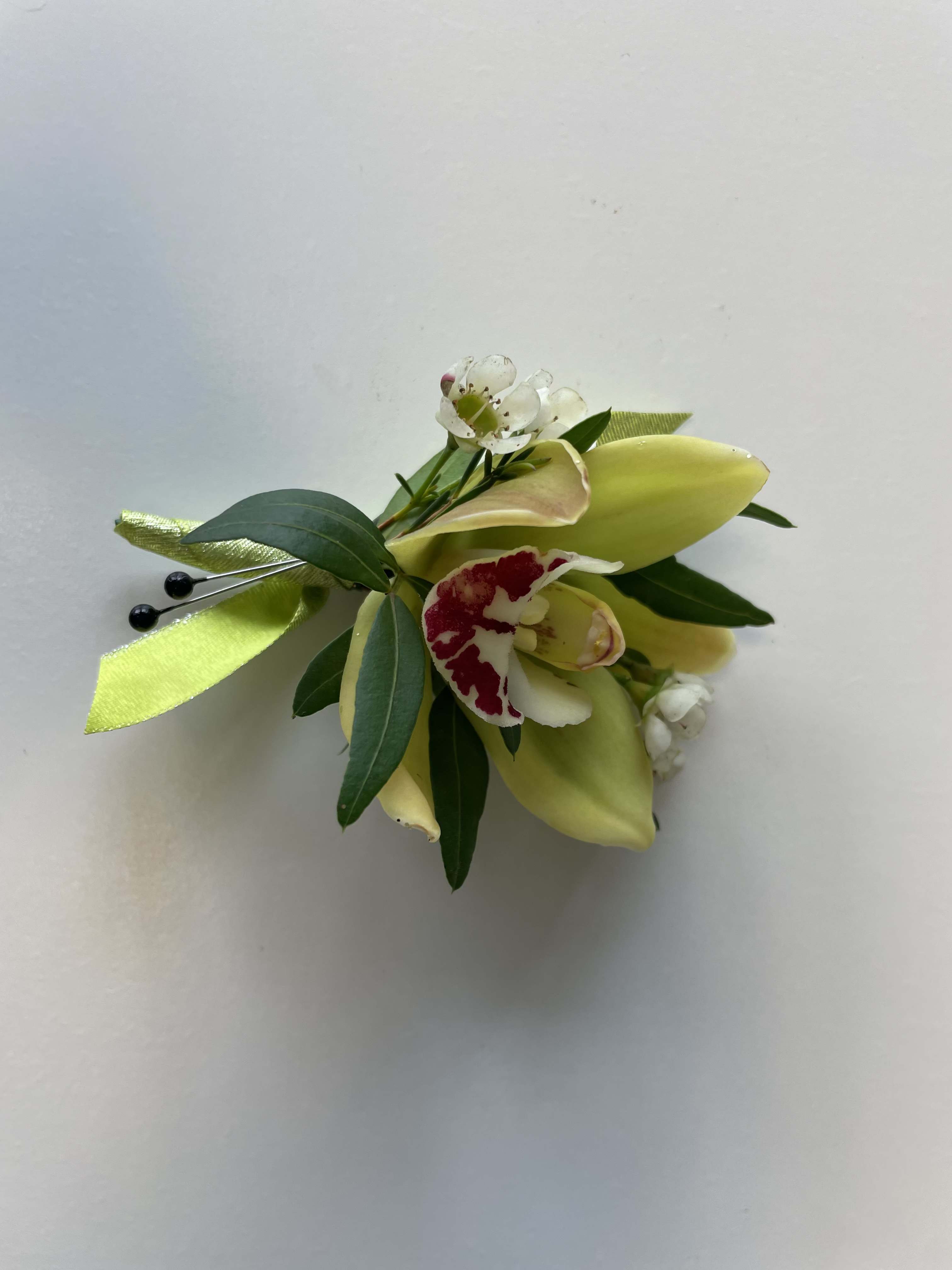 Small floral corsage with pale yellow calla lilies and white blossoms