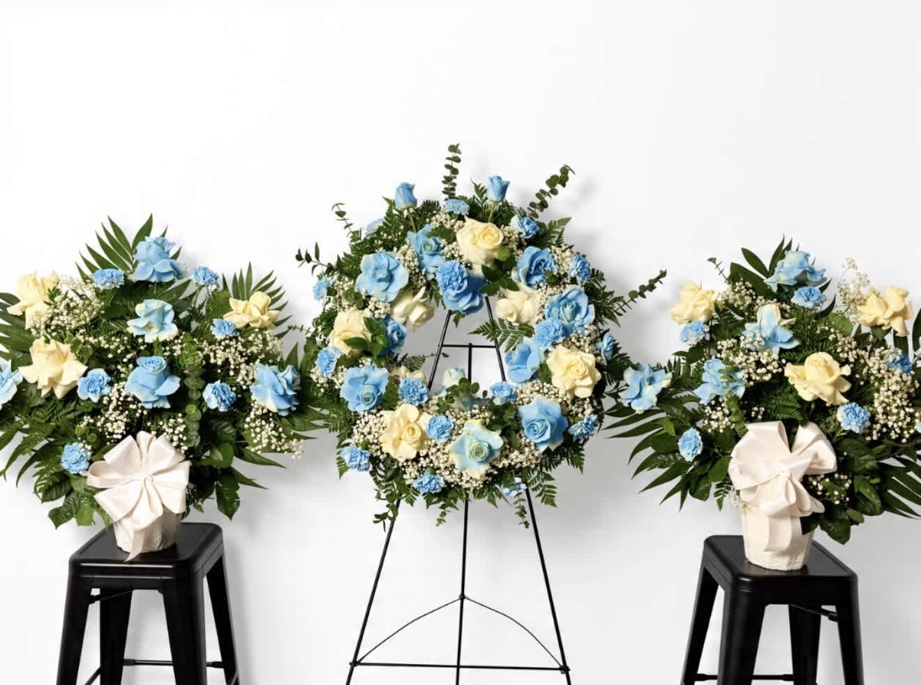 Blue and cream floral wreaths and arrangements on stands and stools