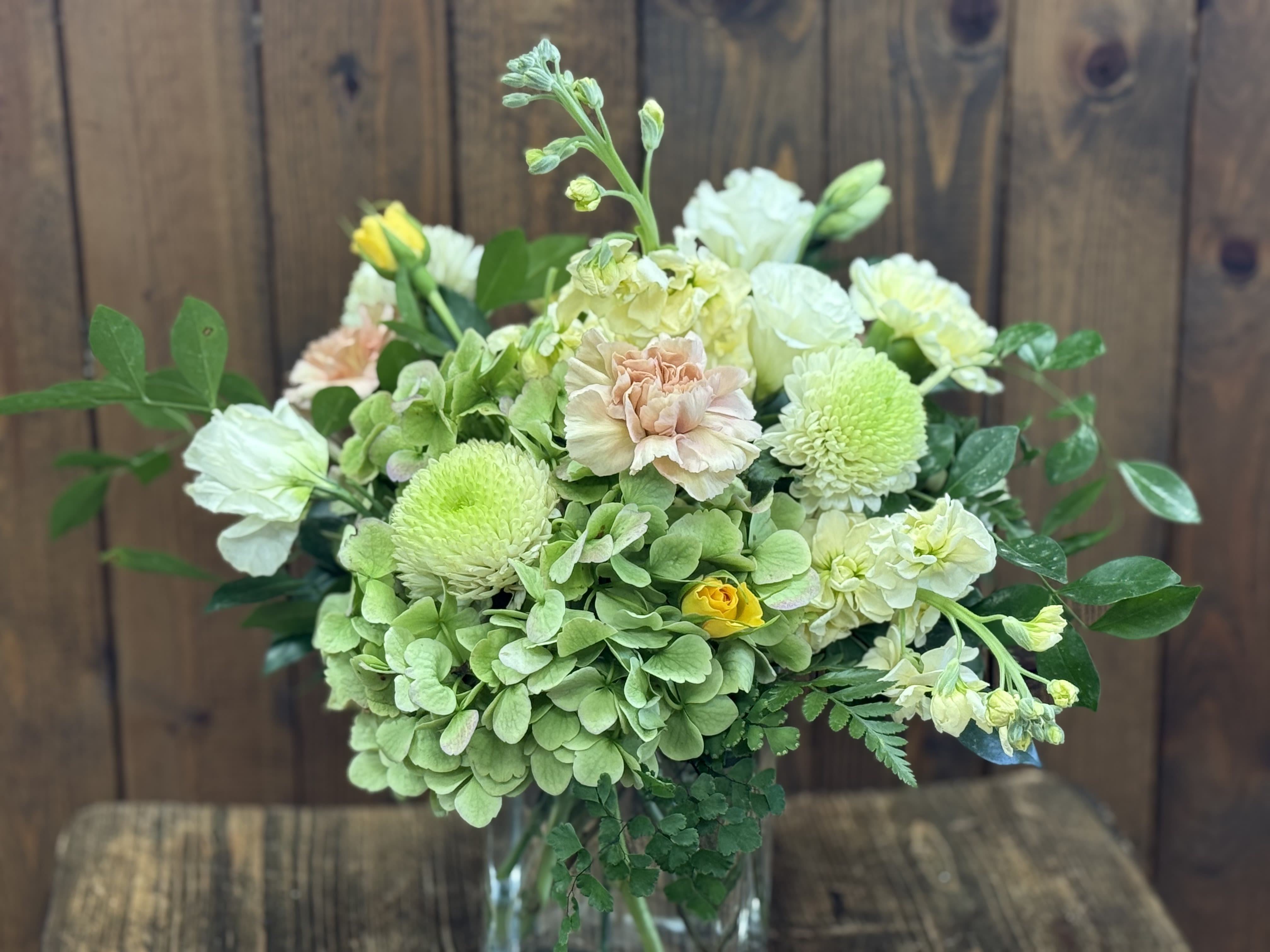 Bouquet of pale green and white flowers in a clear glass vase