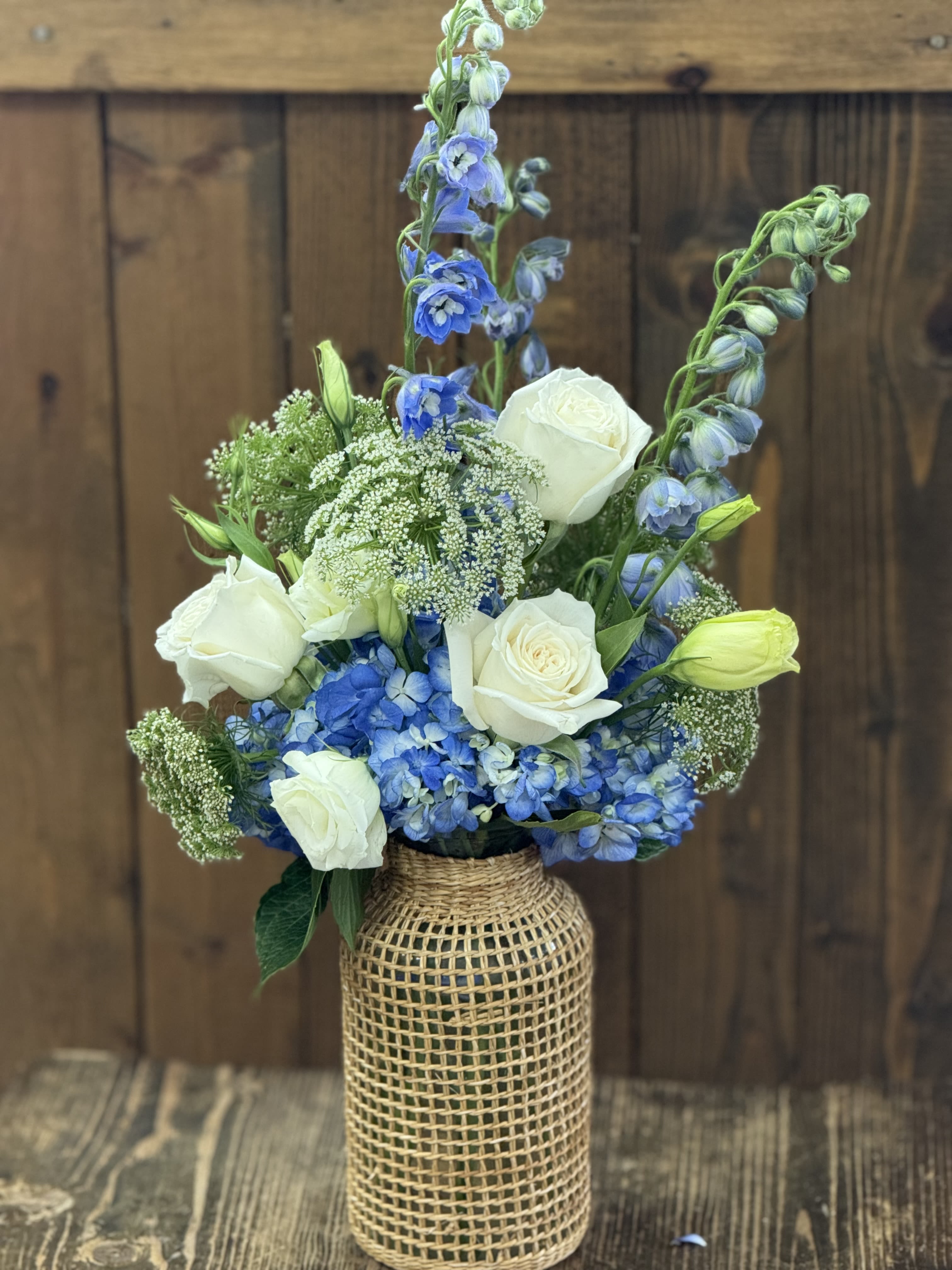 Blue and white floral arrangement in a woven vase