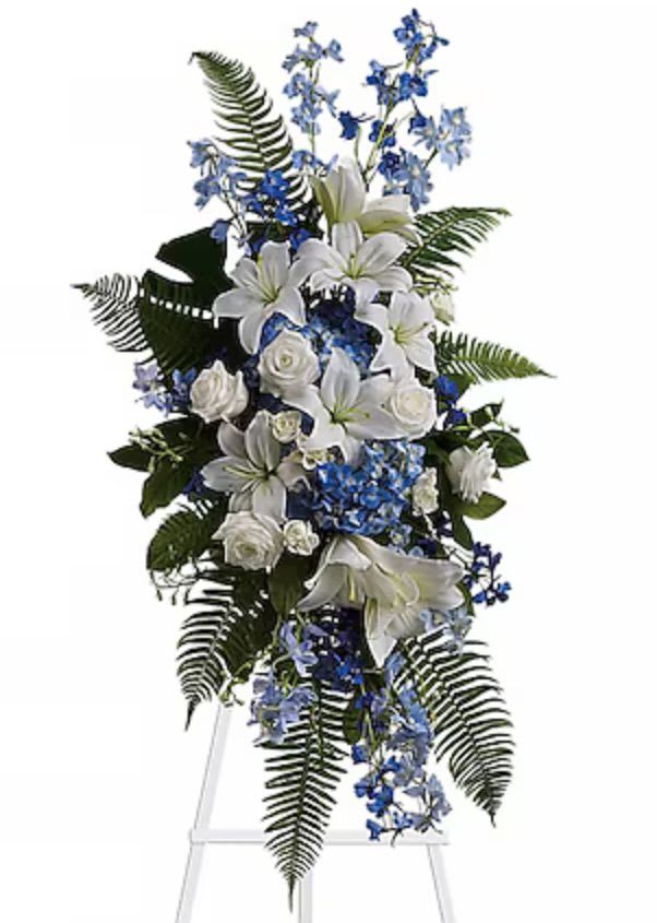 Tall white and blue floral standing spray on an easel