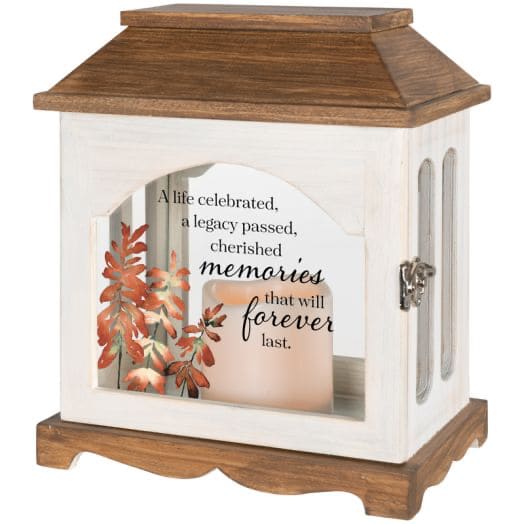 Wooden memorial lantern with a candle and autumn leaves inside