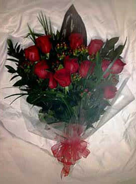 Hand-tied bouquet of red roses wrapped in clear cellophane with a red bow
