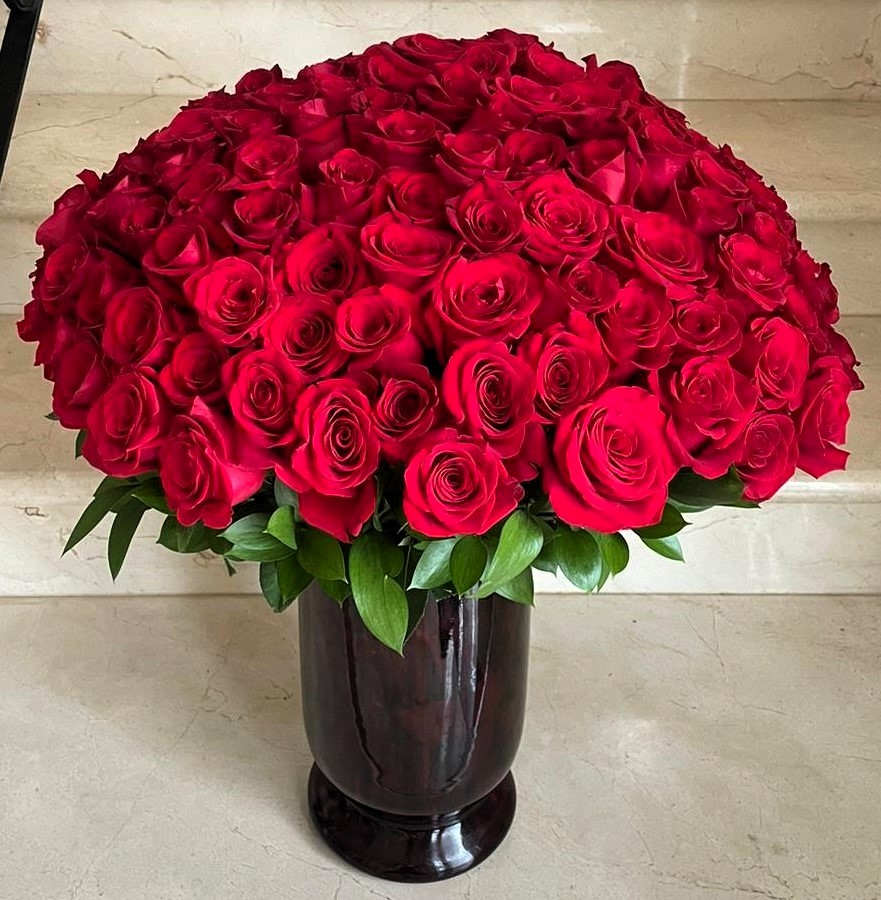Large bouquet of red roses in a dark vase