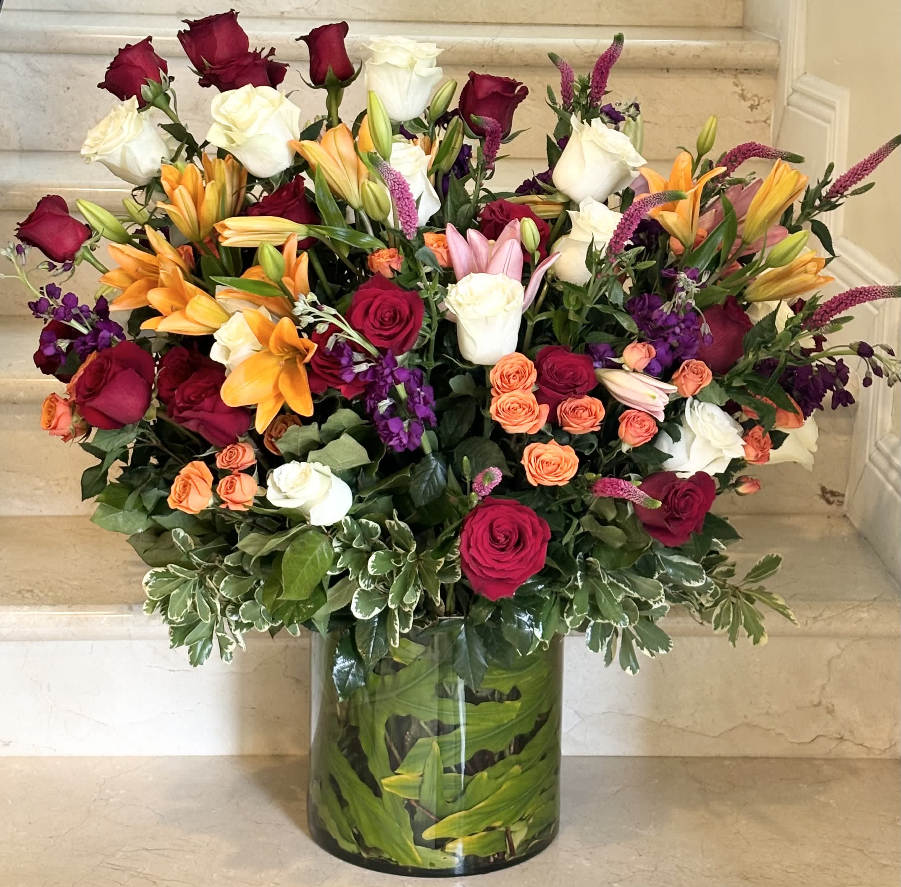 Mixed bouquet of roses and lilies in a glass vase
