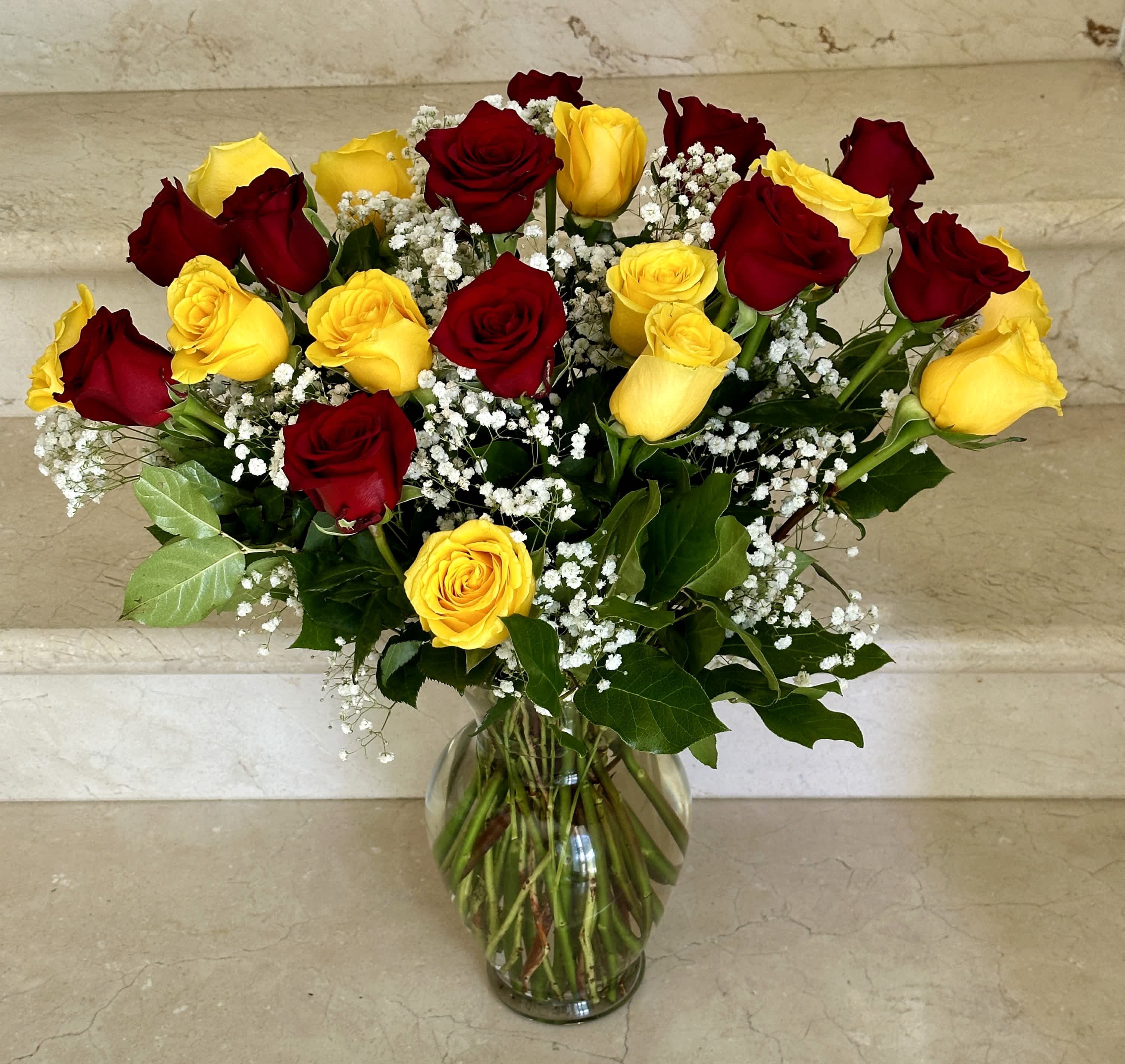Bouquet of red and yellow roses in a glass vase