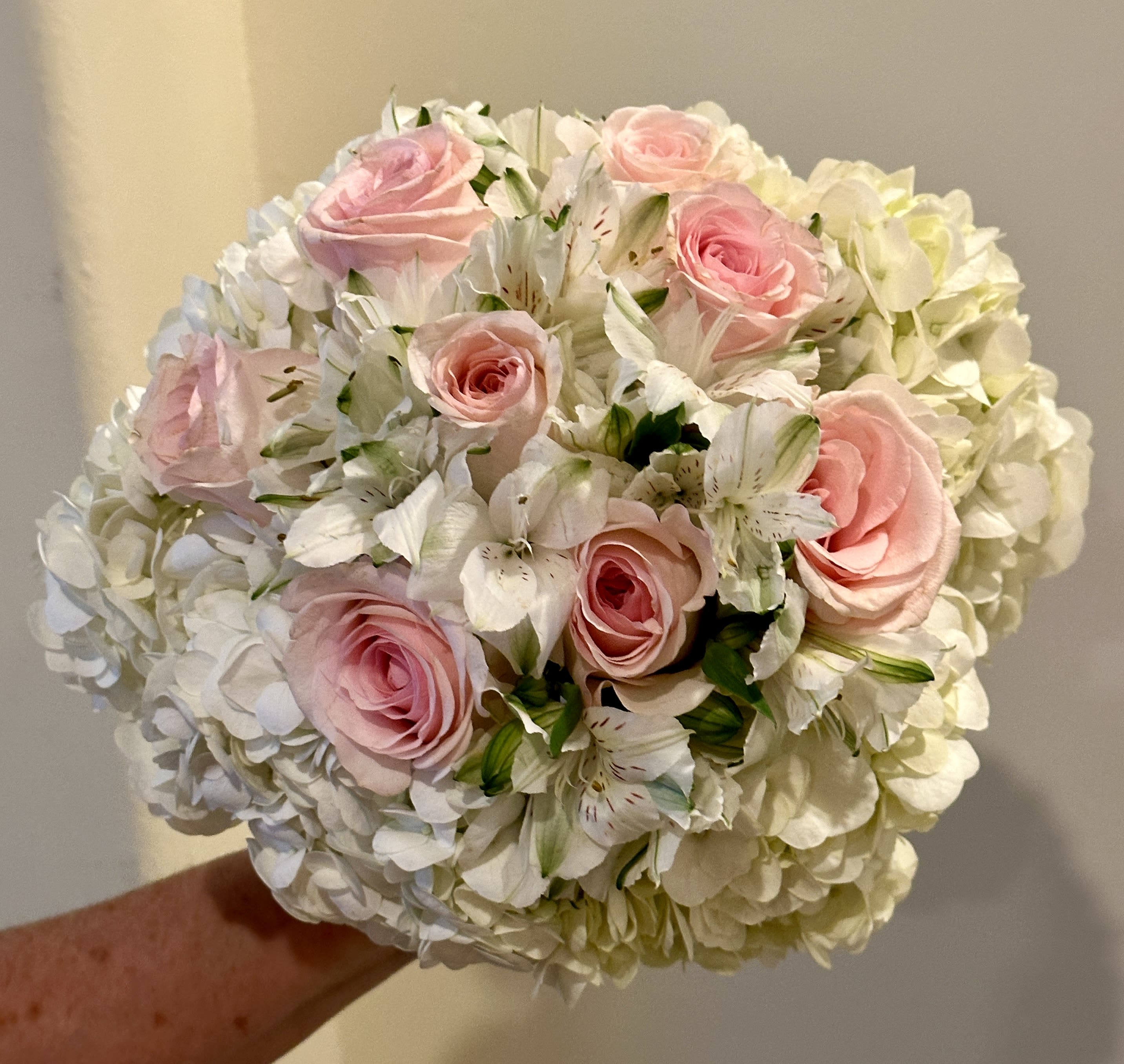 Pink roses and white flowers in a round bouquet