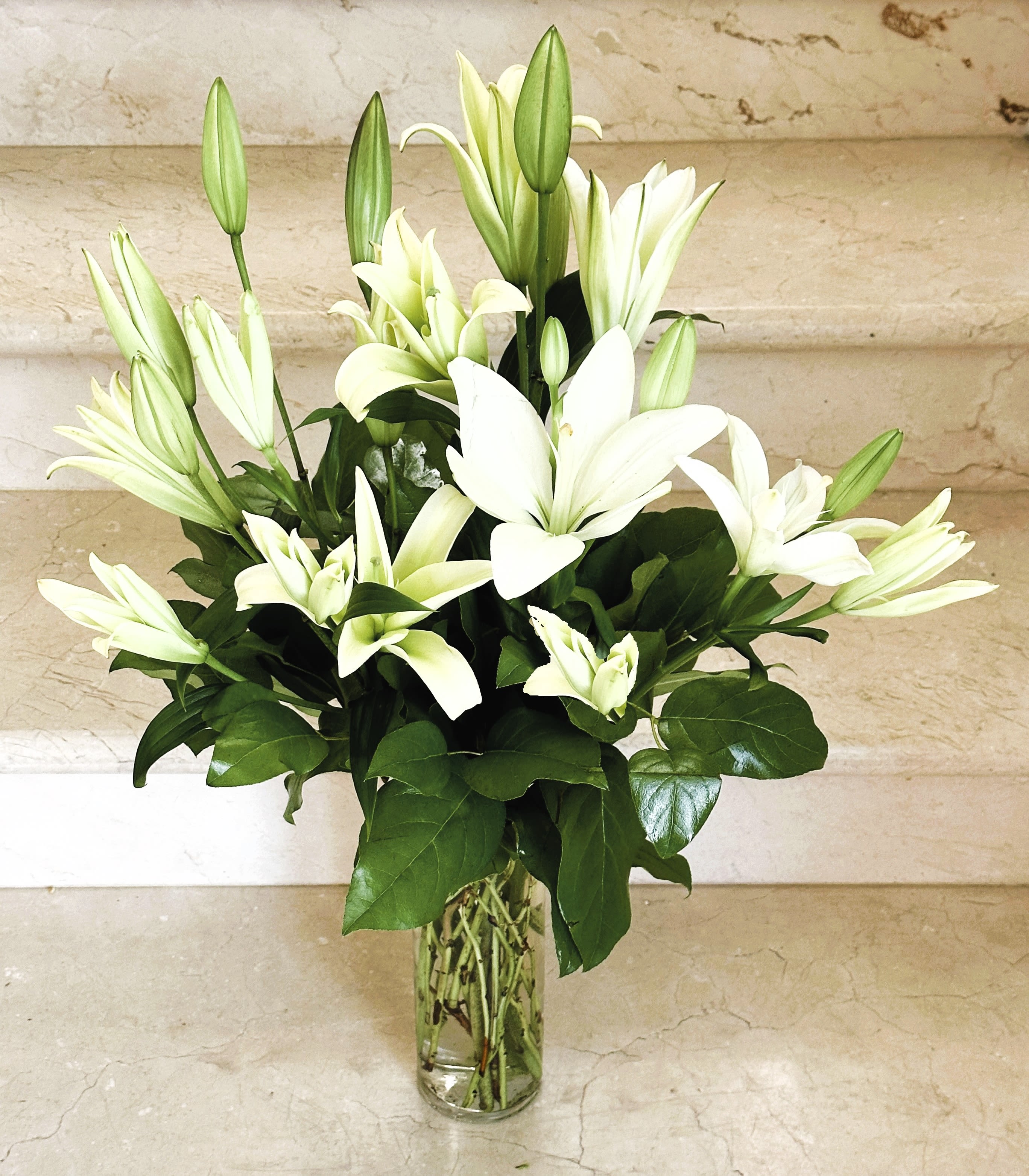 White lilies arranged in a clear glass vase