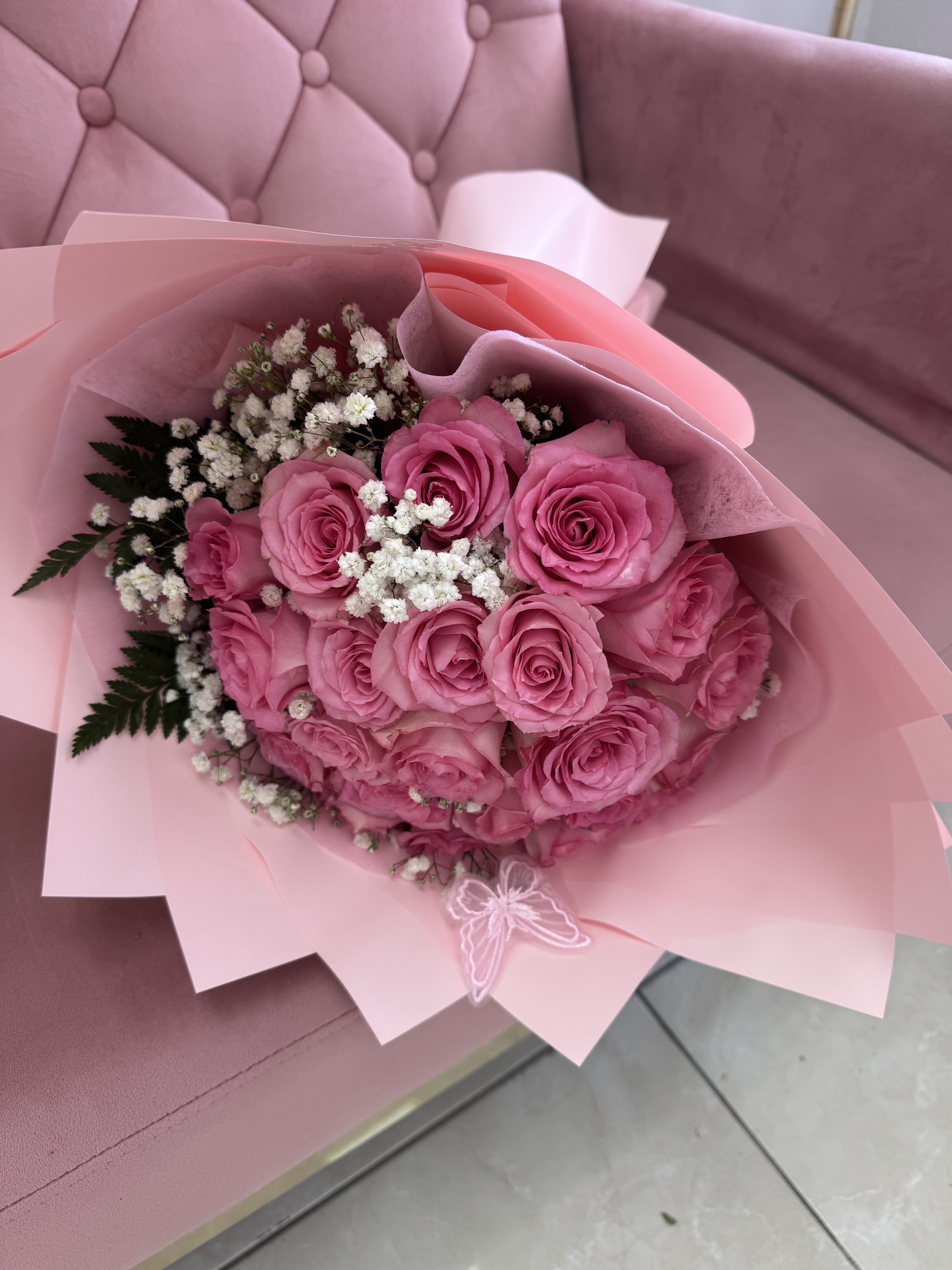Pink rose bouquet with white baby's breath in pink wrapping