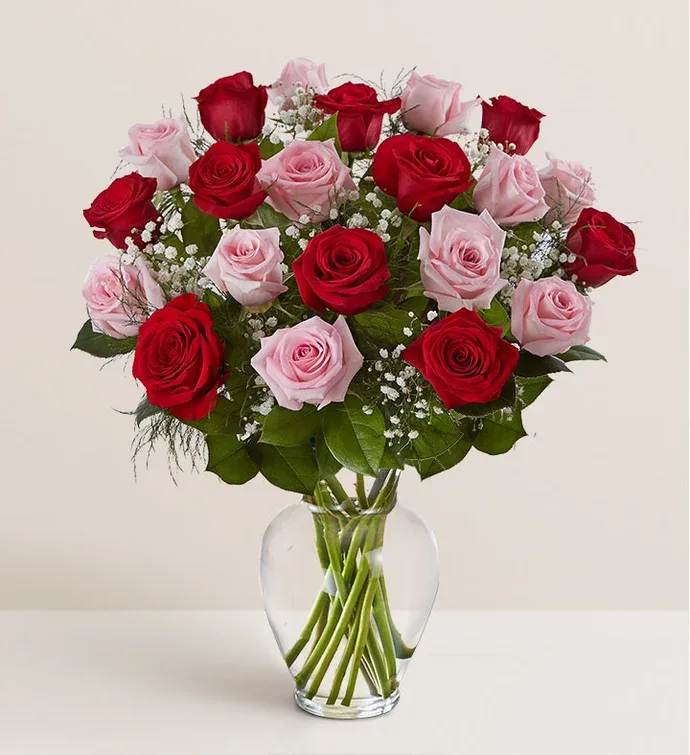 Red and pink roses in a clear glass vase