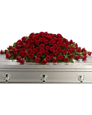 Red rose casket spray on a silver casket