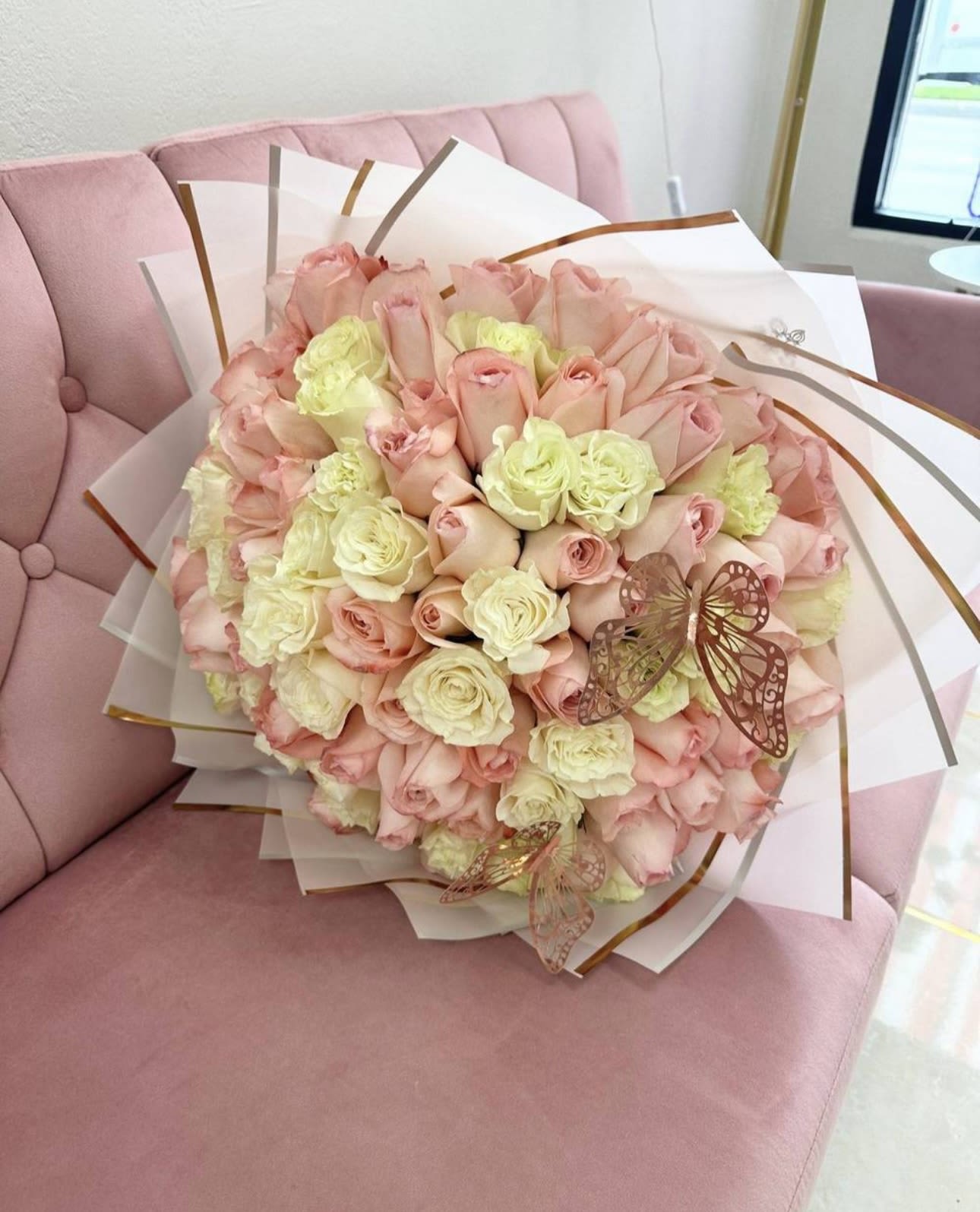 Bouquet of pale pink and cream roses wrapped in white paper