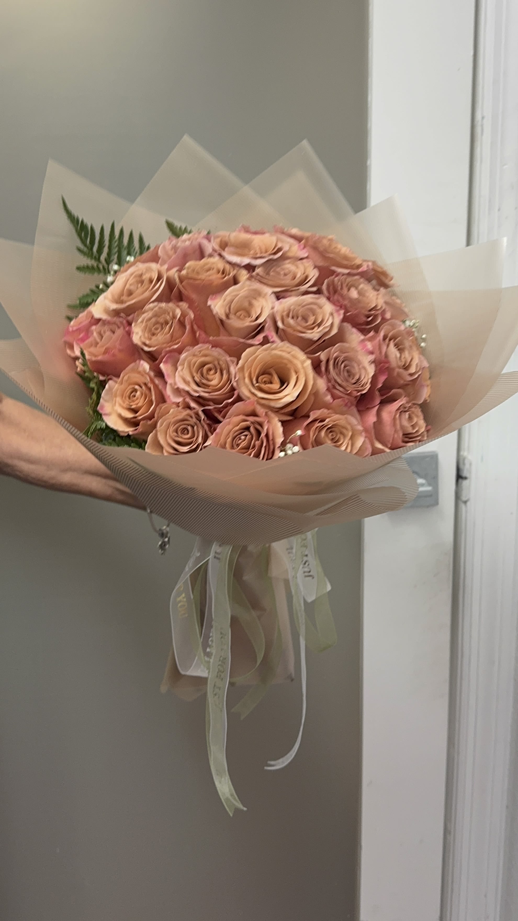 Bouquet of peach roses wrapped in translucent paper