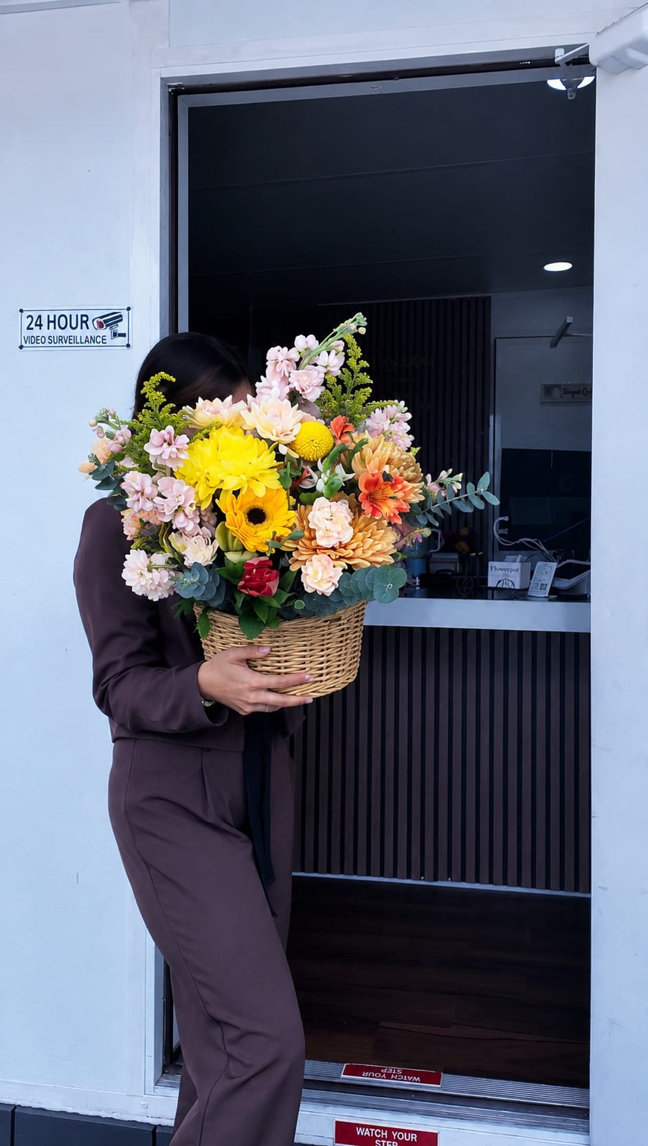 Who said WOW - A burst of sunlit color-this large mixed-color flower arrangement makes an immediate impression as a birthday bouquet, congratulations gift, or joyful thank-you. Who said WOW is an abundant basket arrangement that reads as celebratory and hand-delivered: the bright palette of yellow, pink, orange and peach gives the recipient a lively, uplifting welcome the moment it arrives.  The design features cheerful daisies and bold gerbera daisies, full chrysanthemum blooms, soft rose accents and airy filler set among eucalyptus for texture and movement. All flowers are gathered in a woven basket, giving the piece a rustic, homey feel while keeping stems neatly arranged; the overall look is generous and full without feeling formal.  Perfect for the person you want to brighten-an extra-special pick-me-up, a congratulations for a new job or milestone, or a heartfelt everyday surprise. Sizes are generous; care is simple: keep the arrangement in fresh water, top up as needed, and place out of direct heat to extend bloom life.