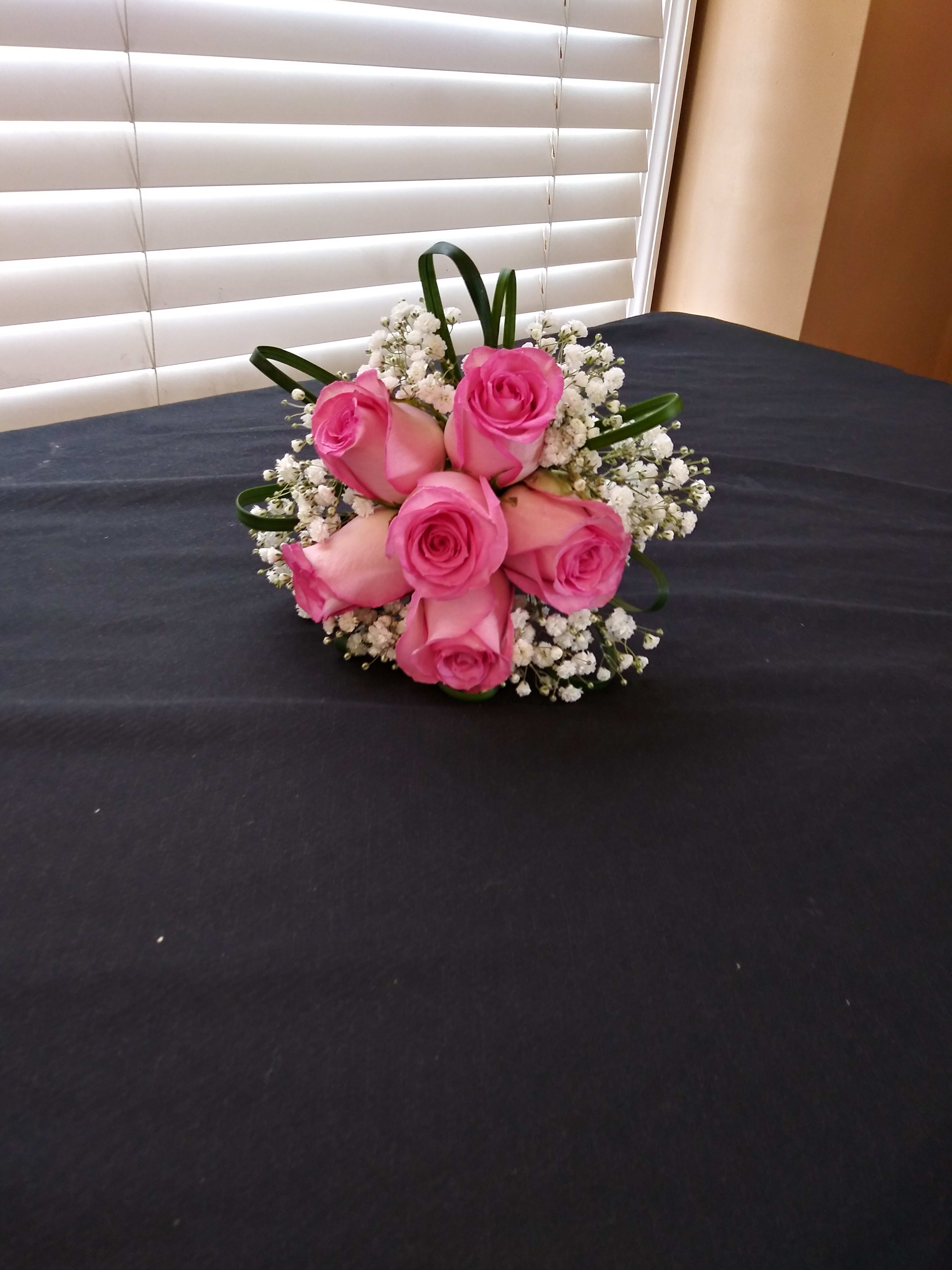 Pink rose bouquet with baby's breath on a dark table