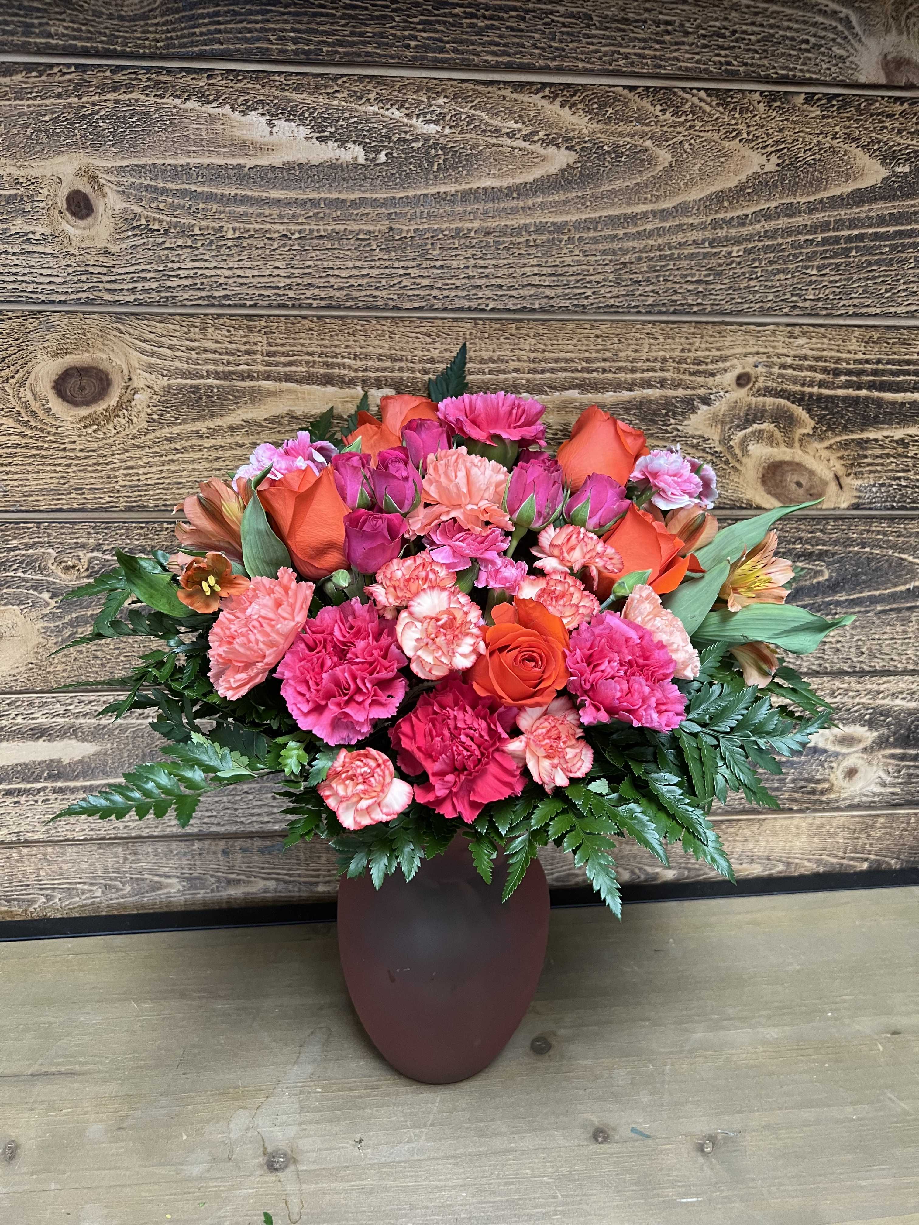 Pink and orange mixed bouquet in a brown vase
