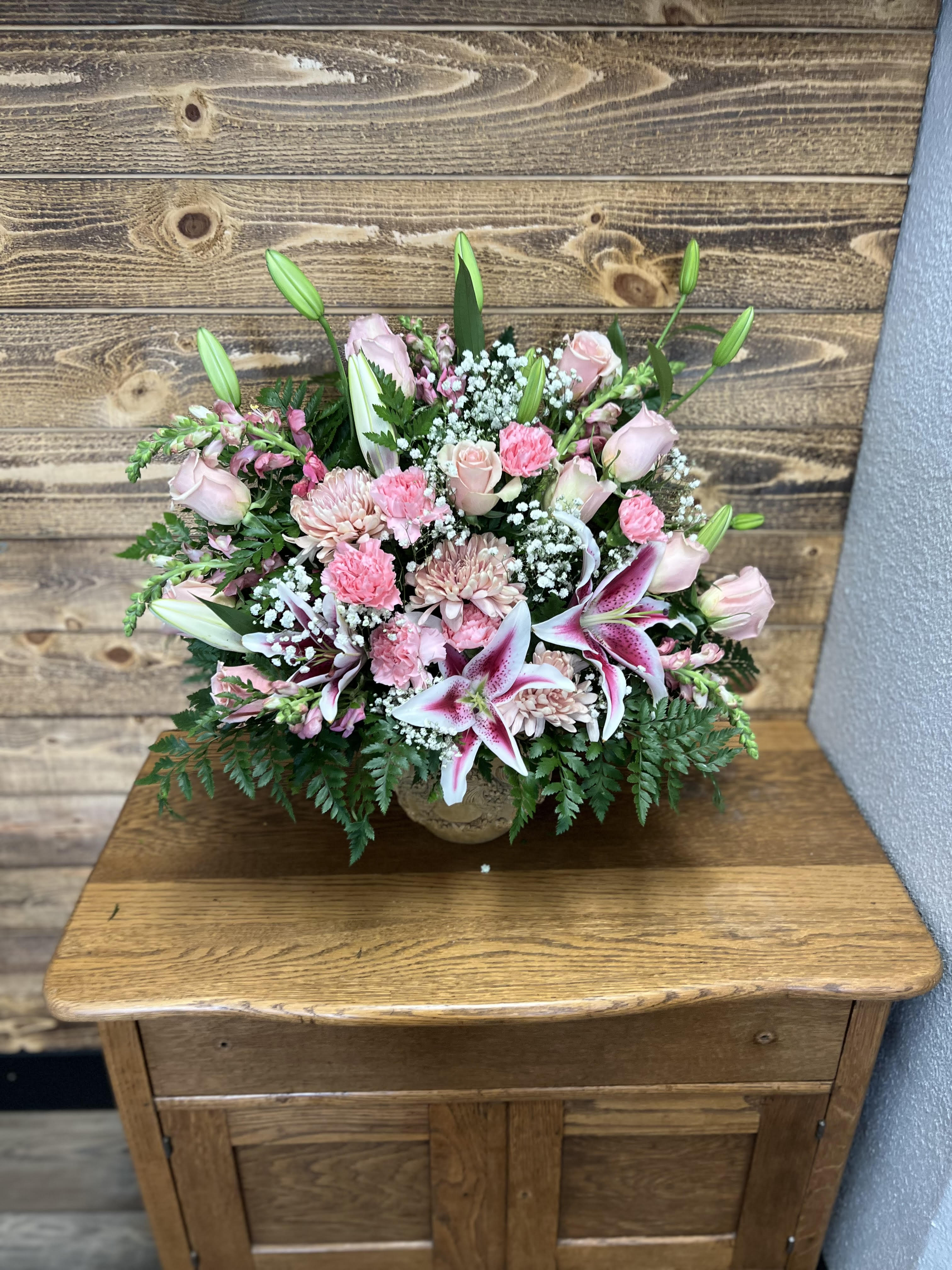 Pink floral arrangement with lilies and roses in a low vase