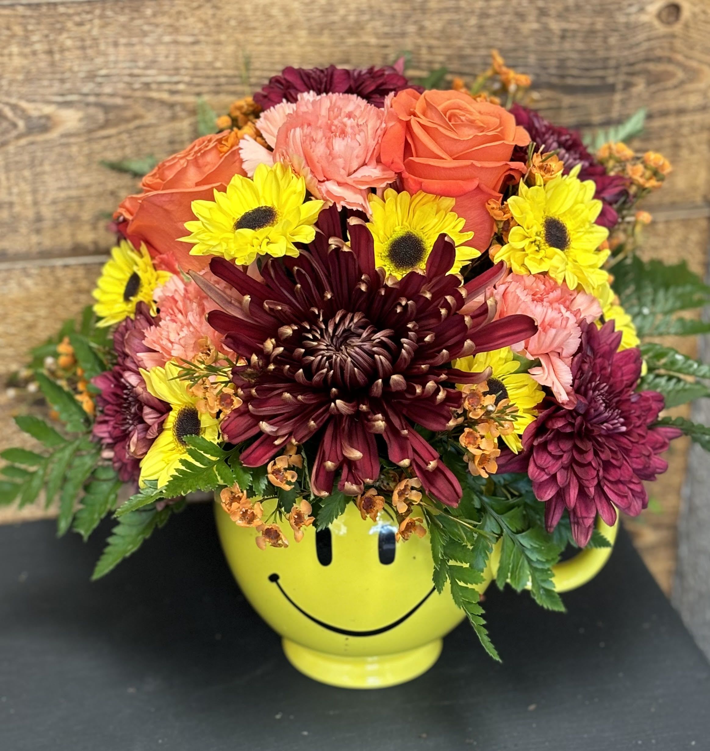 Mixed bouquet in a yellow smiley-face mug