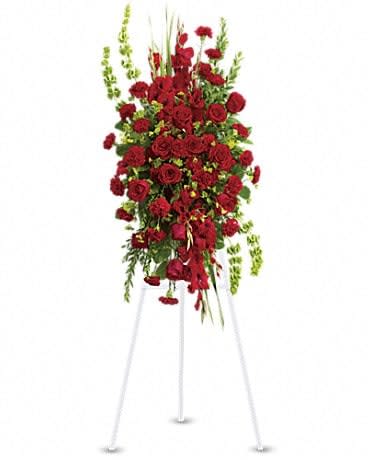 Tall standing spray of red roses on a white easel