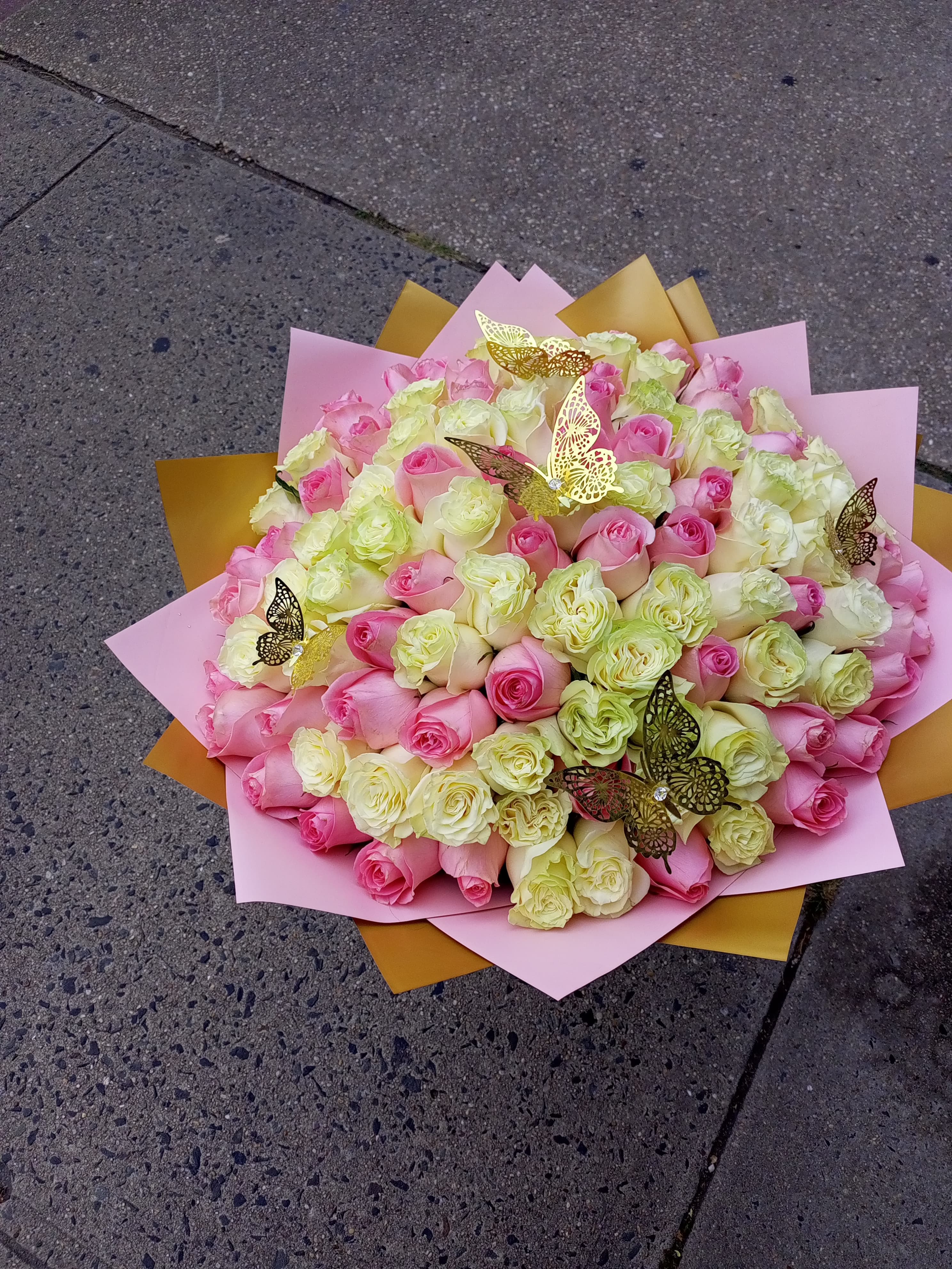 Large bouquet of pink and cream roses with butterfly picks