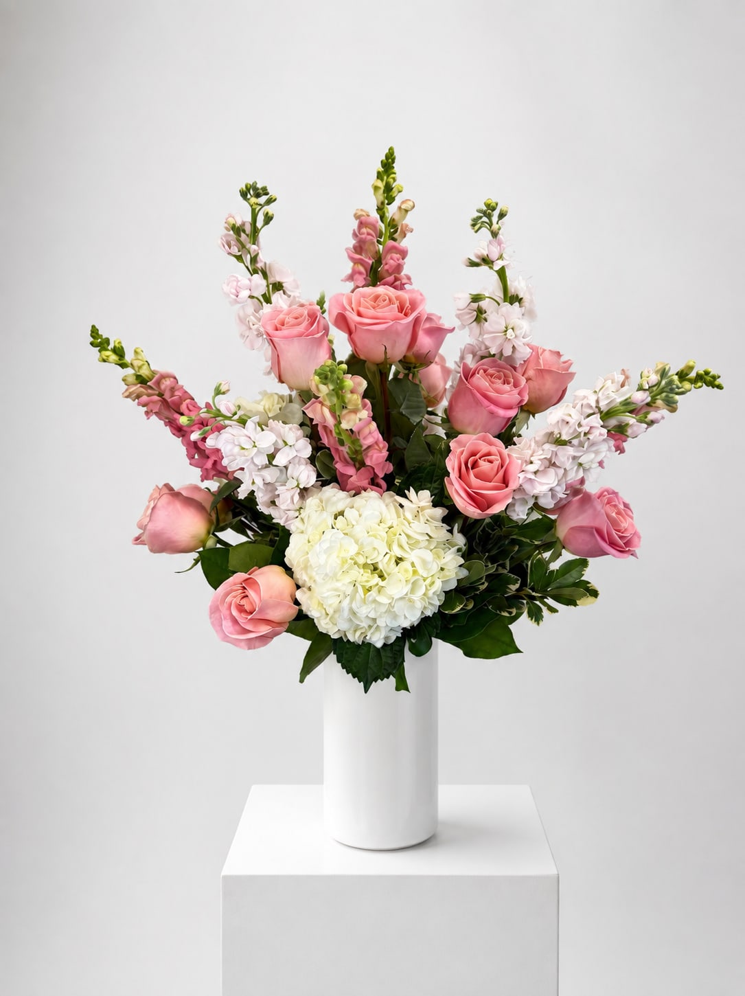 Pink roses and white hydrangea in a white vase