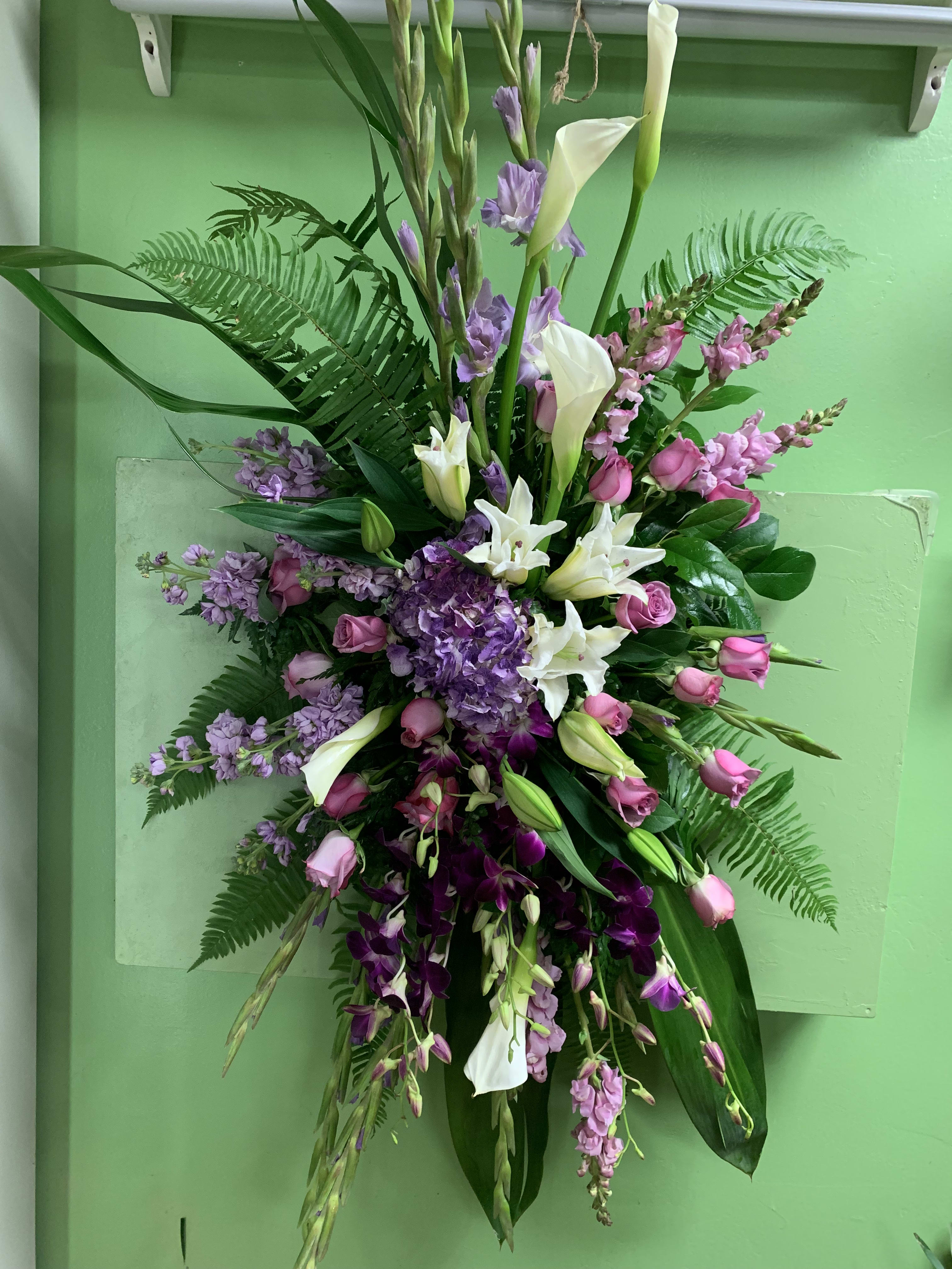 Tall floral spray with white calla lilies, pink roses, and purple blooms