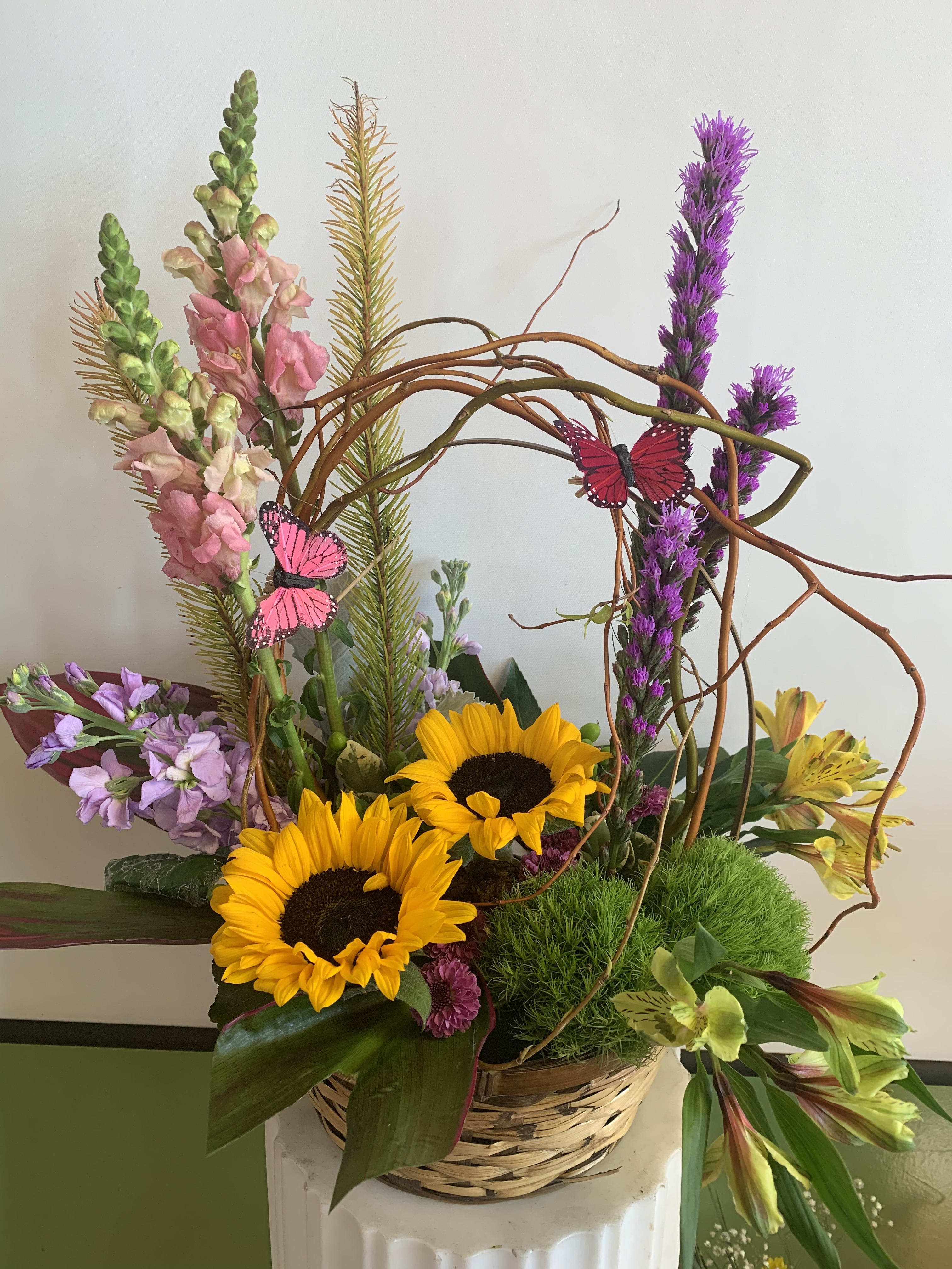 Basket arrangement with sunflowers, snapdragons, and purple flowers